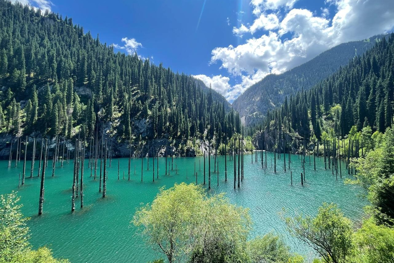 Озеро Каинды с бирюзовой водой и затопленным лесом, окруженное густыми хвойными лесами и горами, Алматы, Казахстан
