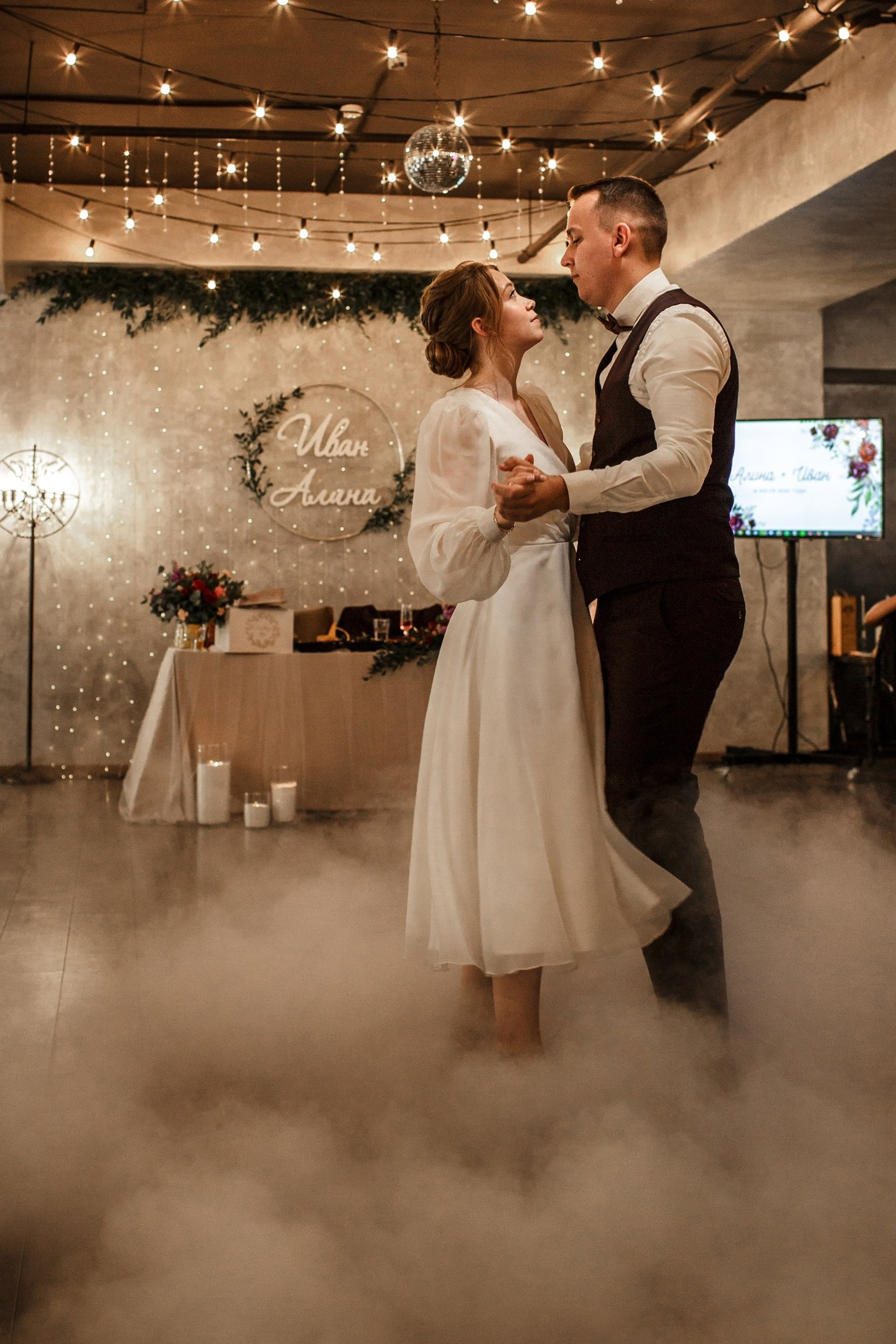 Свадебная съемка на банкете: первый танец молодоженов с тяжелым дымом.