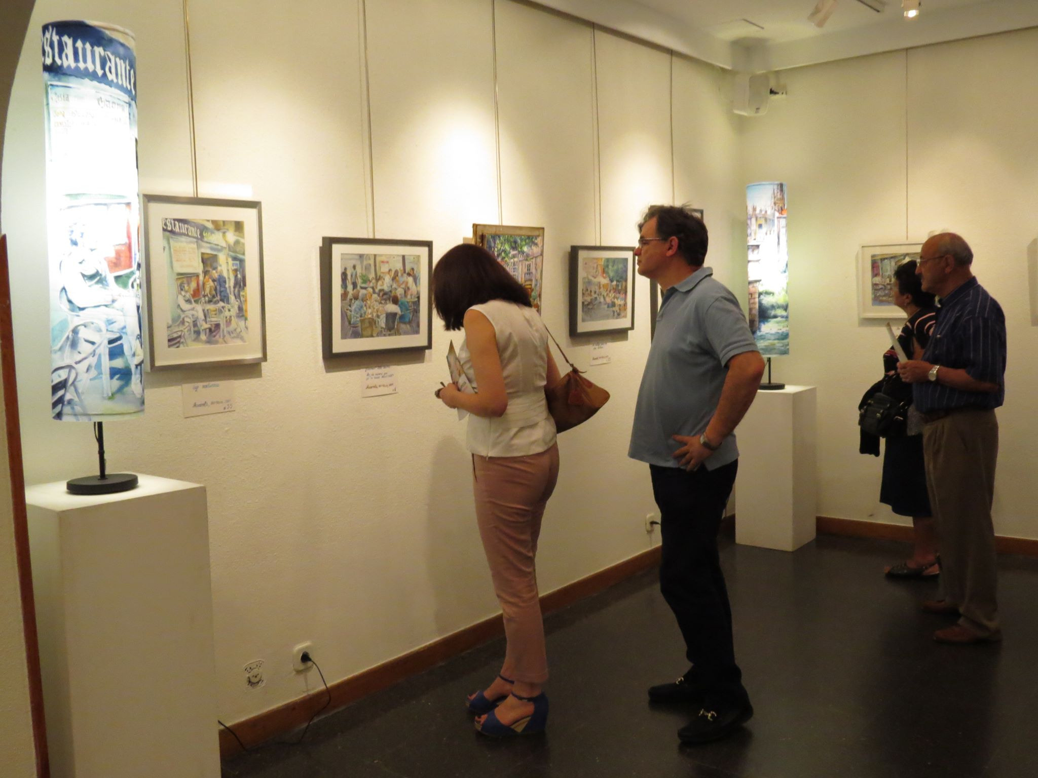 Visitors examine paintings