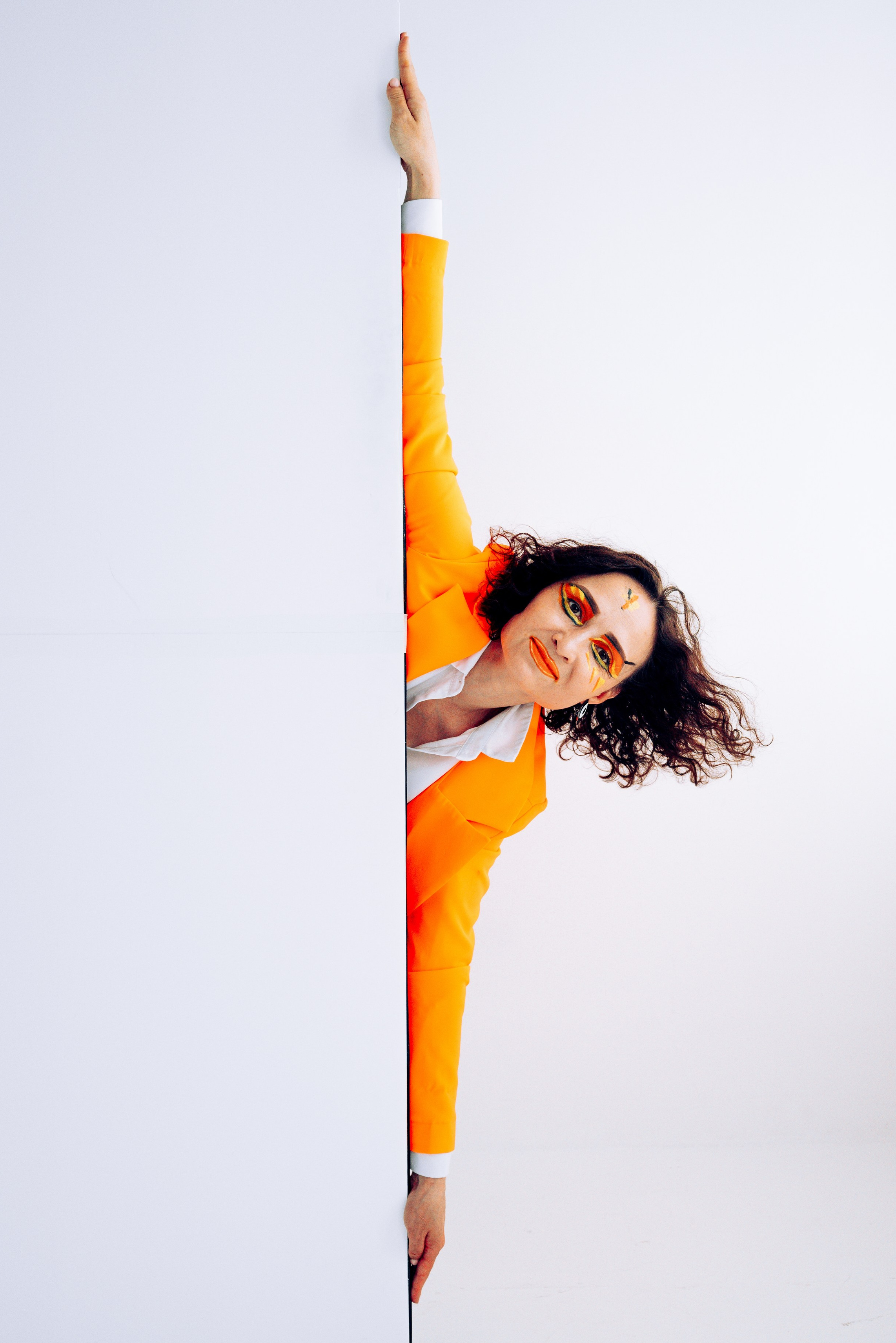 творческая девушка в оранжевом пиджаке на белом фоне