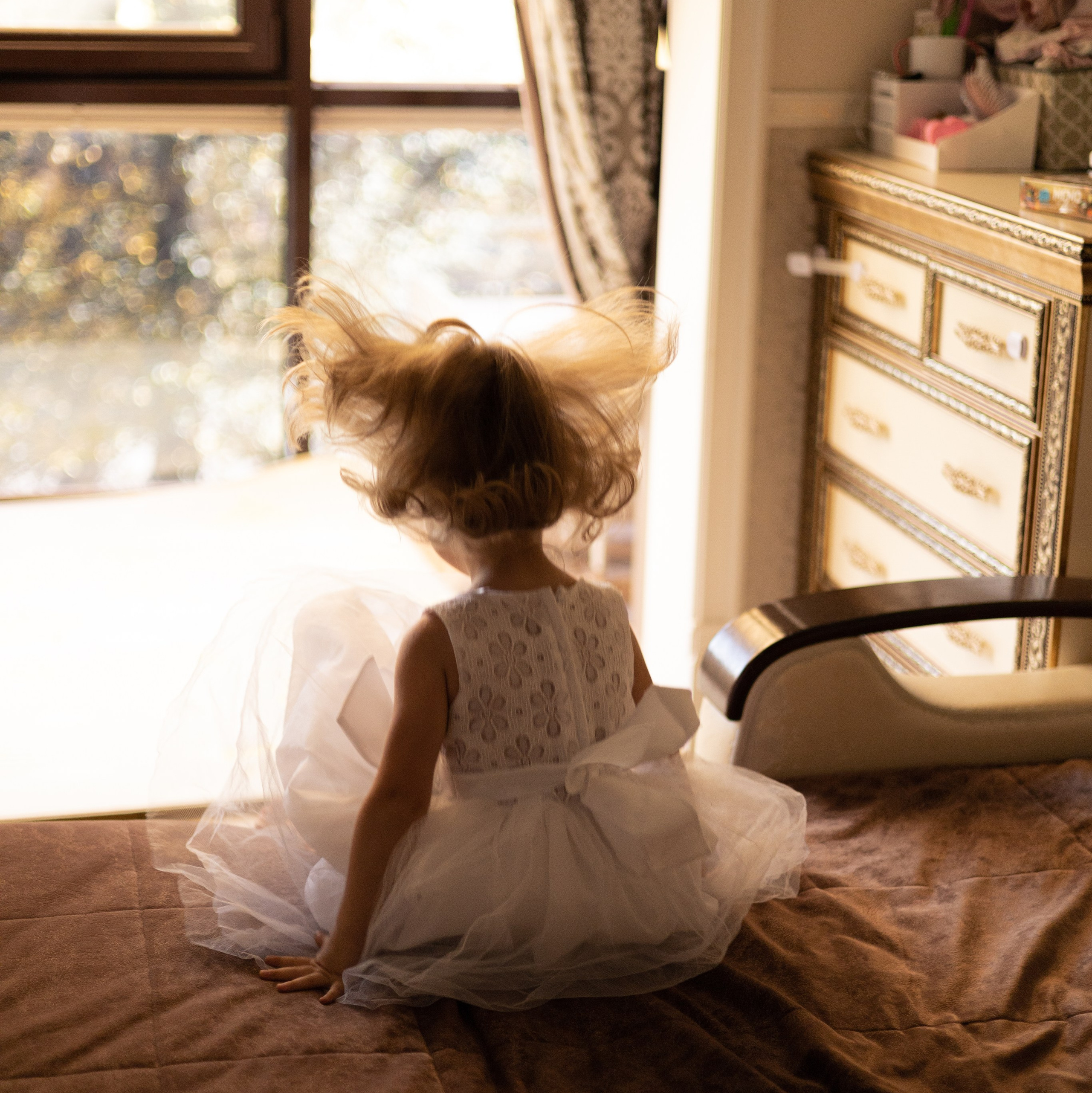 Маленькая девочка прыгает на диване