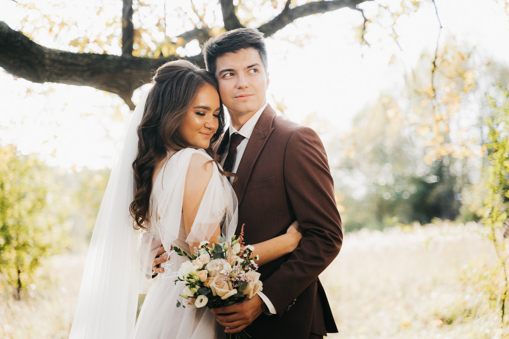 Невеста и жених в под дубом в золотой час 