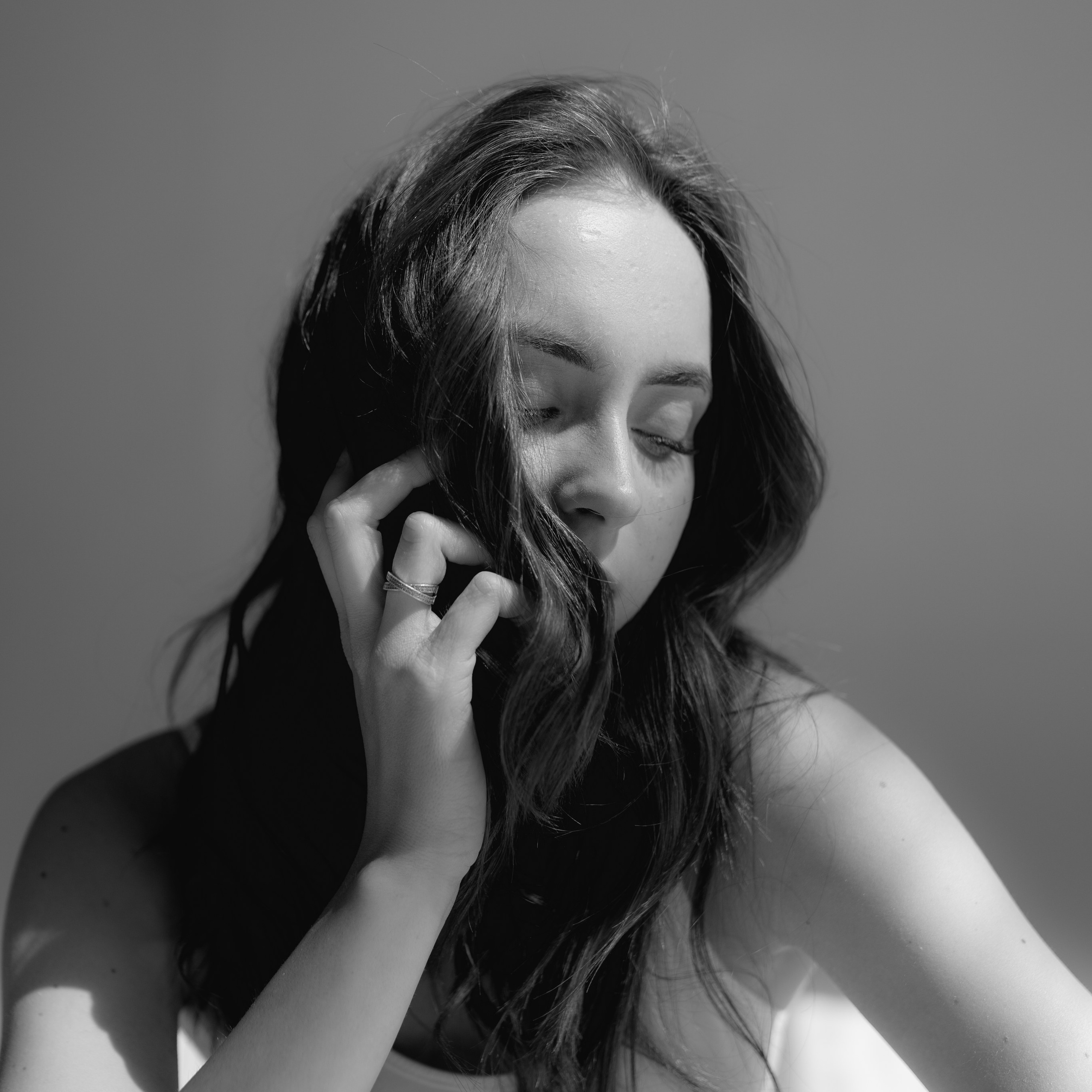 Чёрно-белый портрет девушки с рукой у лица