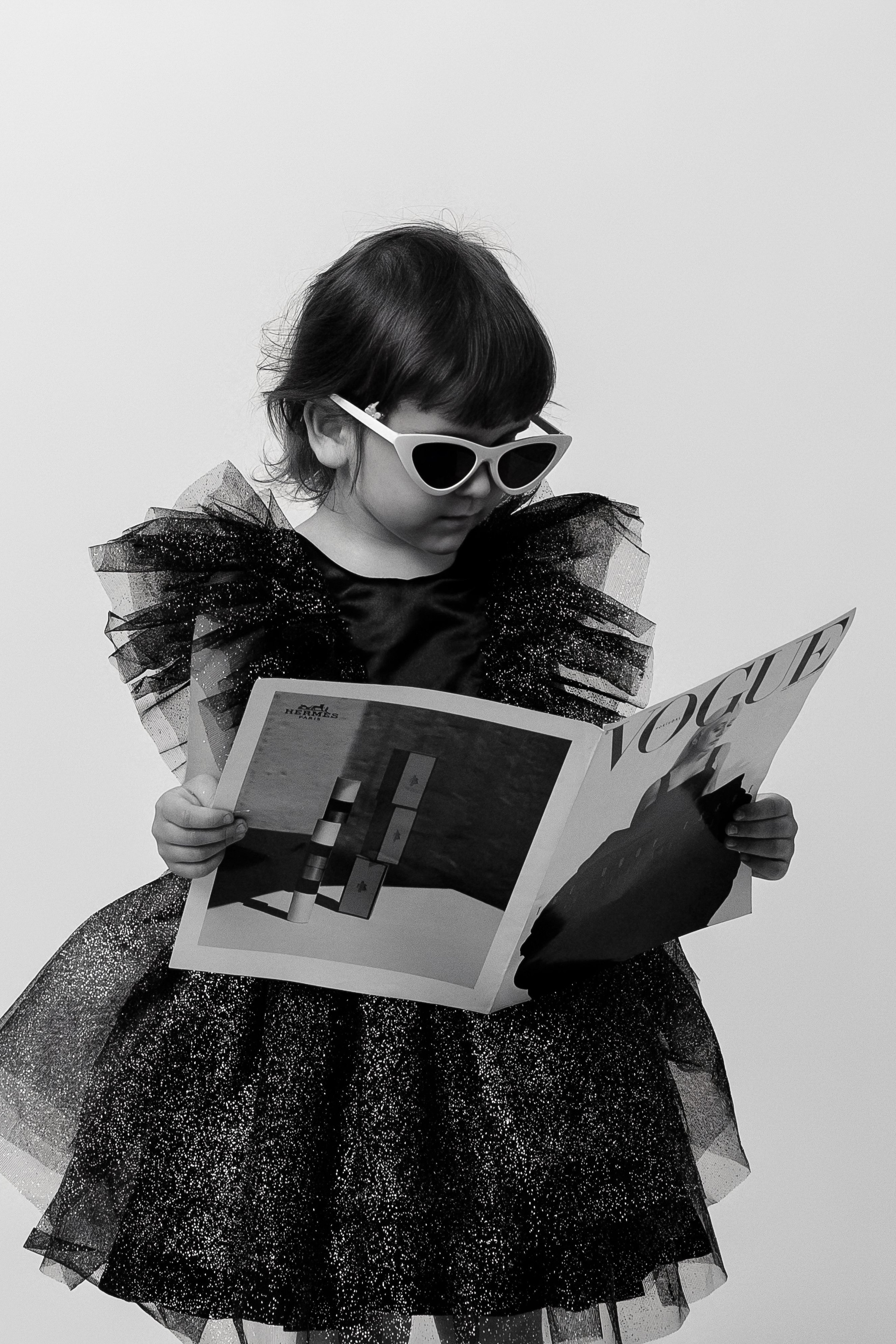 детская фотосъемка модная девочка в очках читает журнал