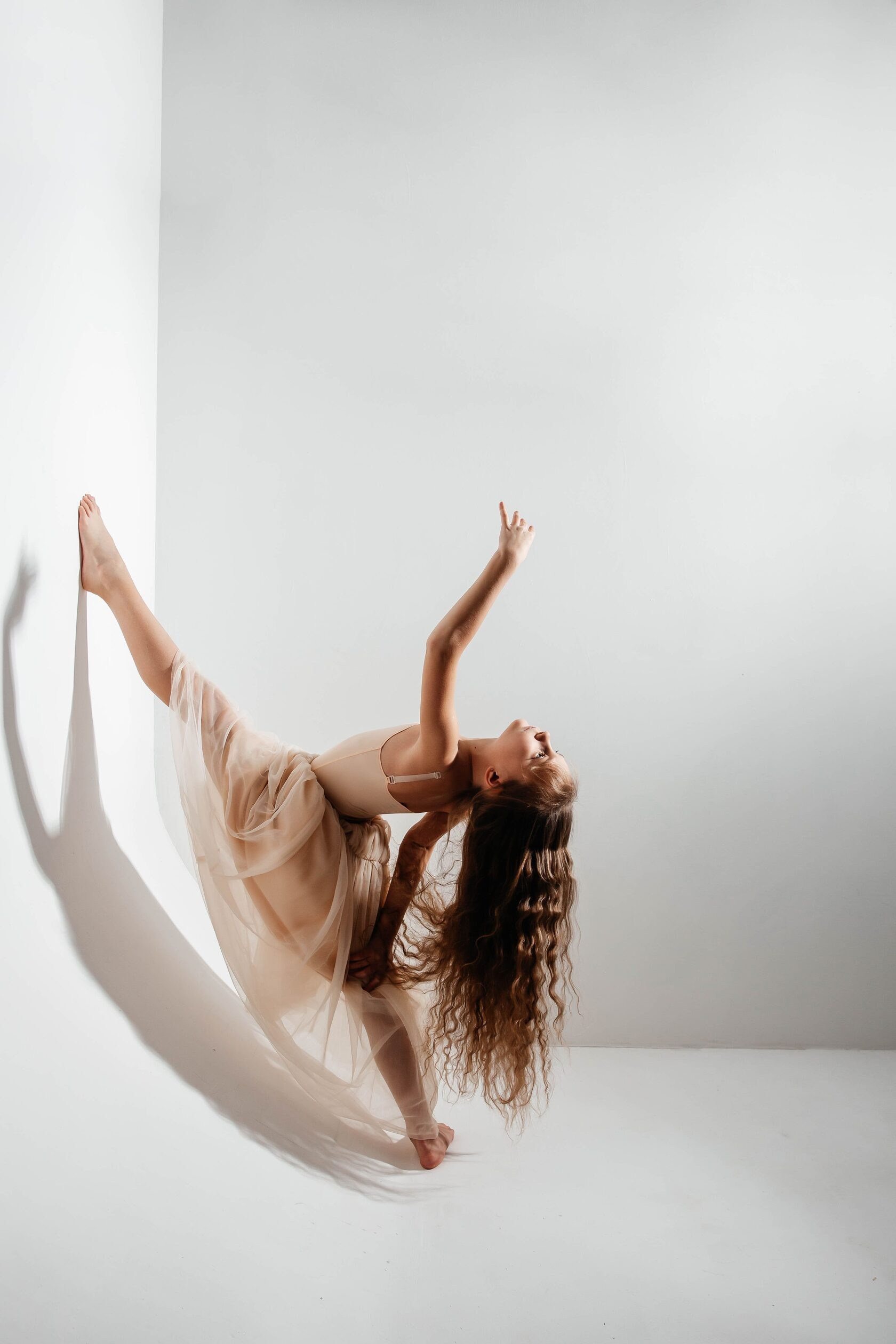 Необычный шпагат девочки на студийной циклораме