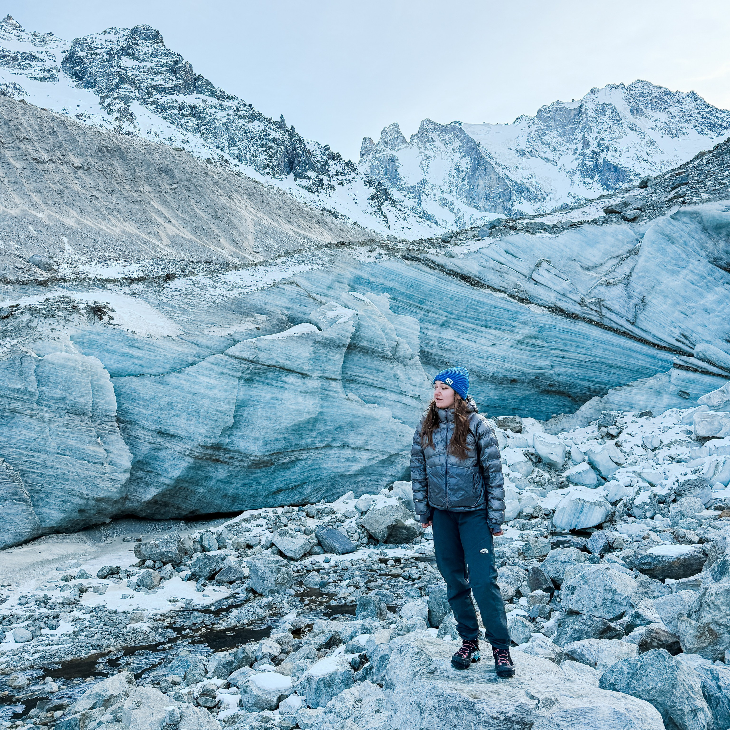Девушка на леднике в Приэльбрусье на фоне заснеженных гор