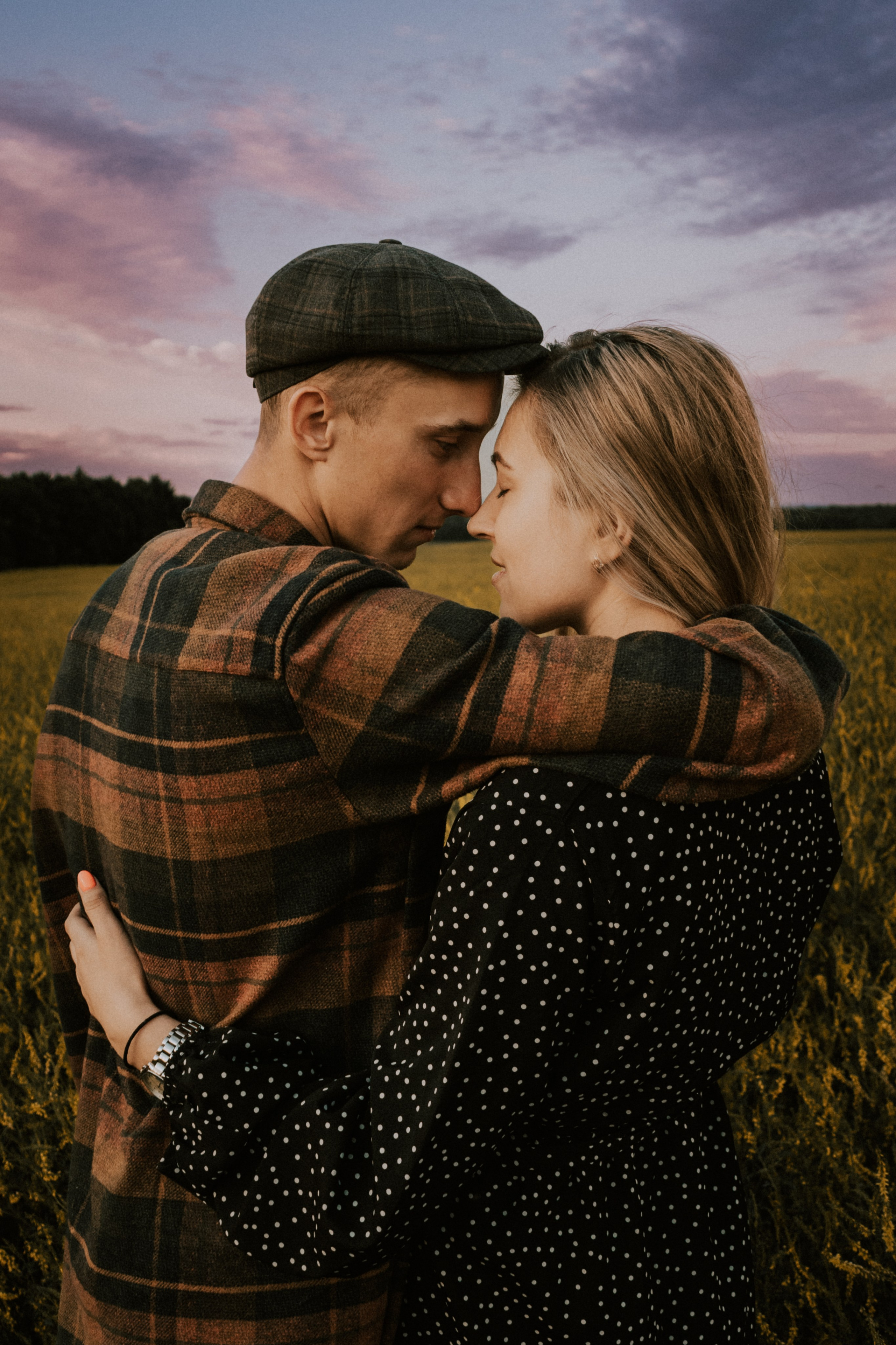 Love story фотосессия на фоне красивого розового неба и поля