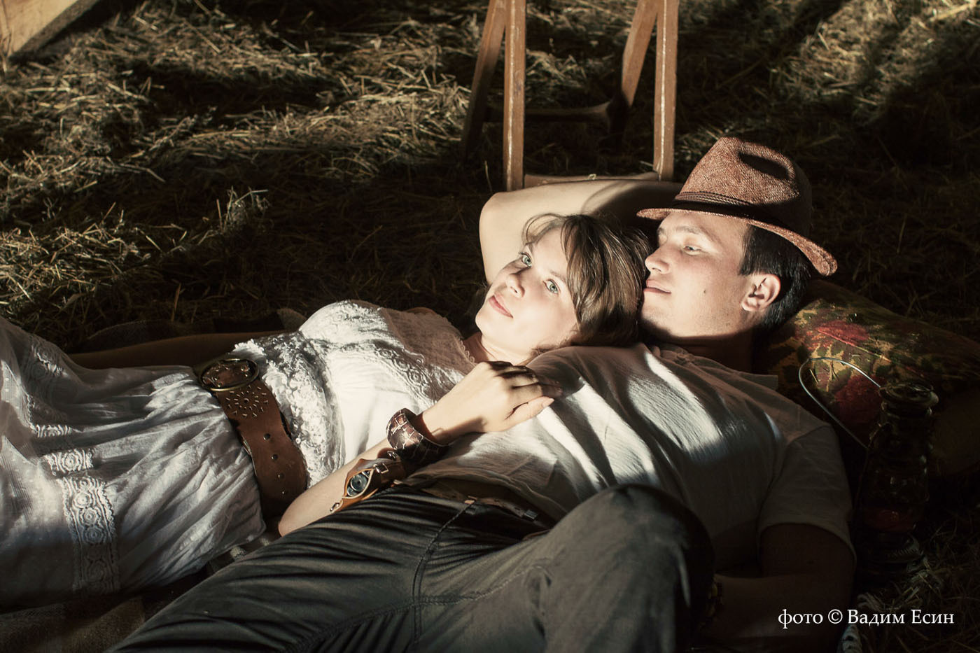 Представдебная фотосессия лавстори: на фото девушка и юноша лежат на сеновале в луче света, Love story, лавстори, лав стори.