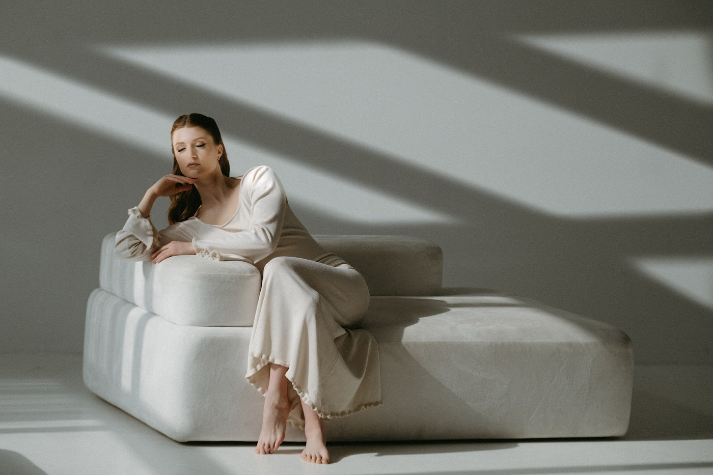 пара молодоженов стоит на мостике украшенным оранжевой тканью и держит цветной дым оранжевого цвета