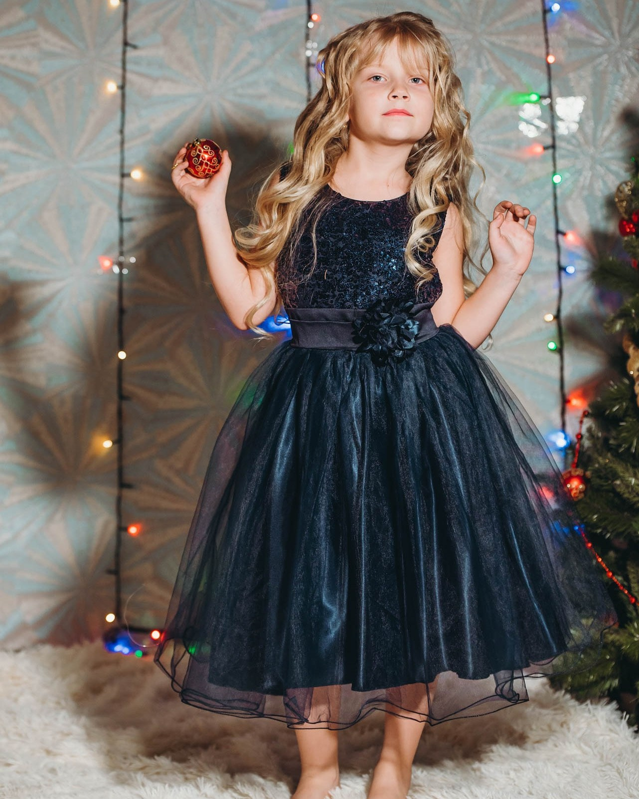 Девочка в вечернем черном платье с пайетками на новогодней фотосессии