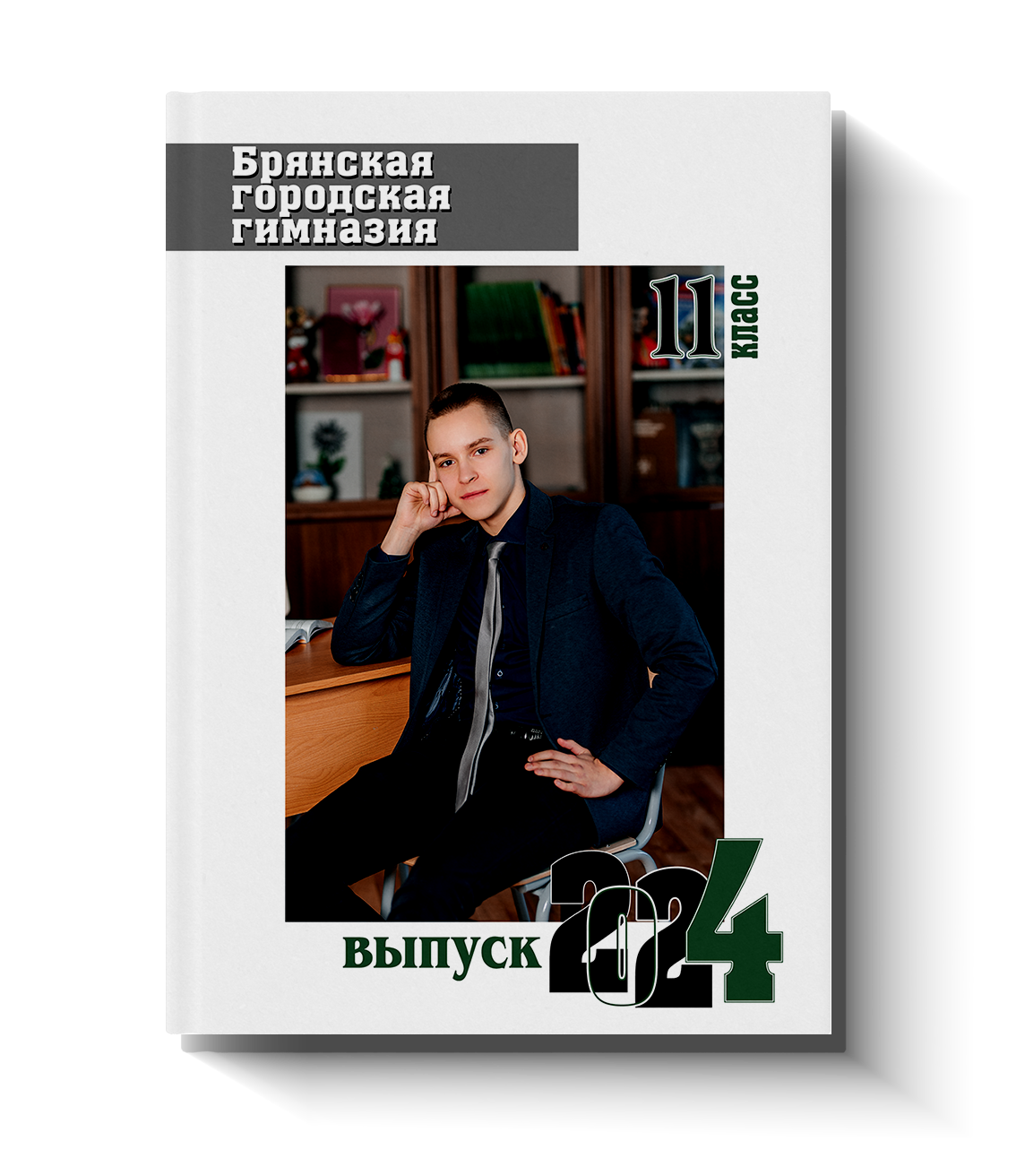Обложка школьного альбома с портретом выпускника в пиджаке, сидящего возле парты на фоне стеллажа с книгами.