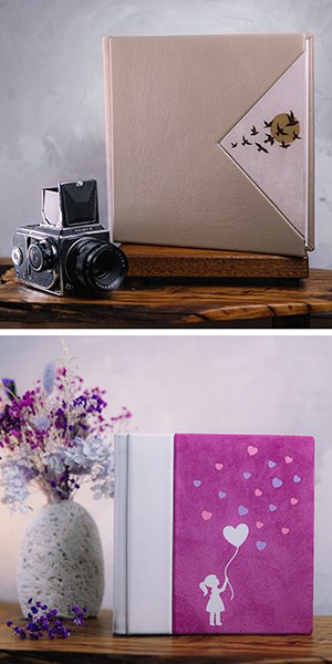 На верхнем снимке бежевая фотокнига с треугольной вставкой и силуэтами летящих птиц стоит рядом с винтажной среднеформатной камерой. На нижнем — ярко-сиреневая книга из замши с белым силуэтом девочки, держащей сердце-воздушный шар.