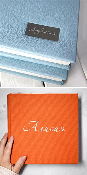 Премиальная фотокнига из голубой натуральной кожи с именным шильдом и оранжевый тканевый альбом с каллиграфическим тиснением.