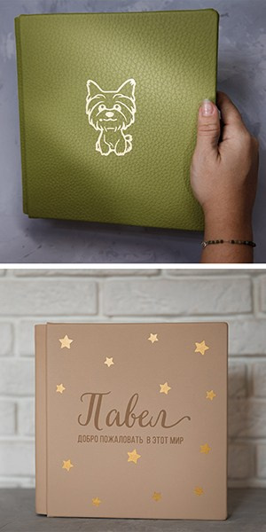 Кожаная фотокнига оливкового цвета с золотым тиснением в виде щенка и бежевый детский альбом «Павел. Добро пожаловать в этот мир» с россыпью звезд.