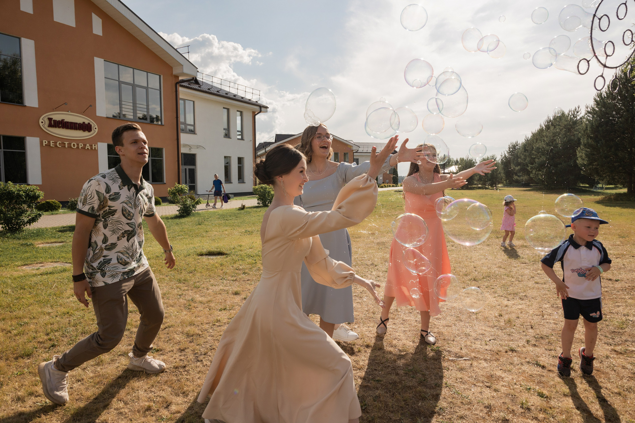 Выпускница смеётся с друзьями на репортажной съёмке