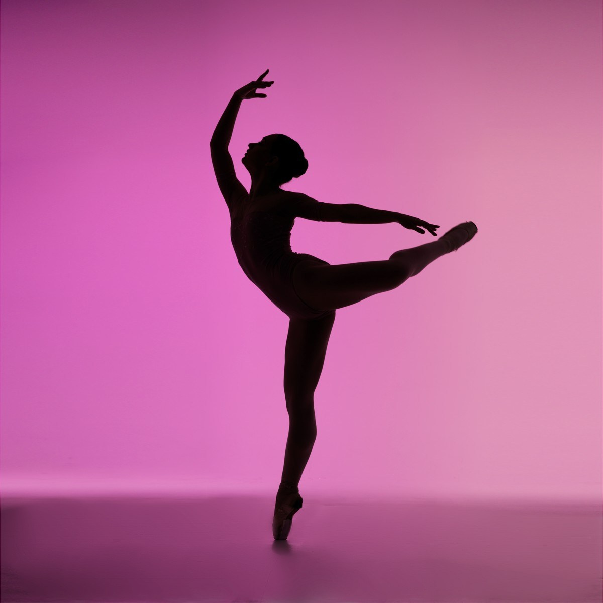 Эстетичный силуэт балерины в танцевальной позе на розовом фоне, снятый спортивным фотографом в Тюмени