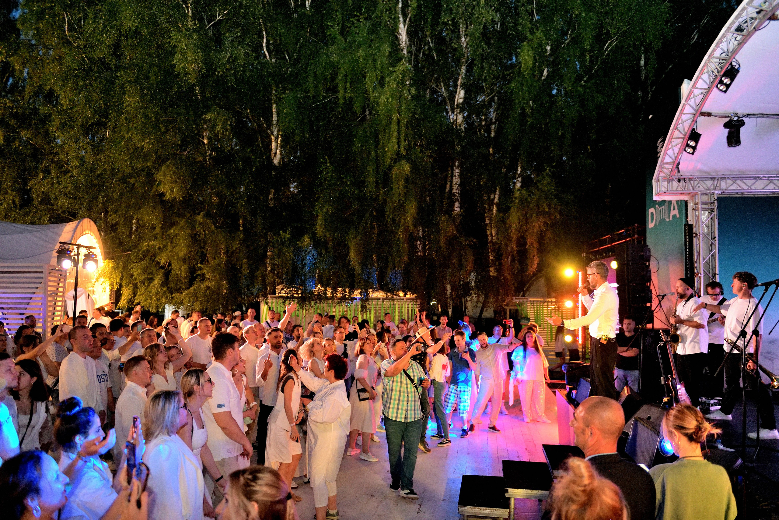 "Танцующая аудитория на летнем корпоративе в парке "Березы".