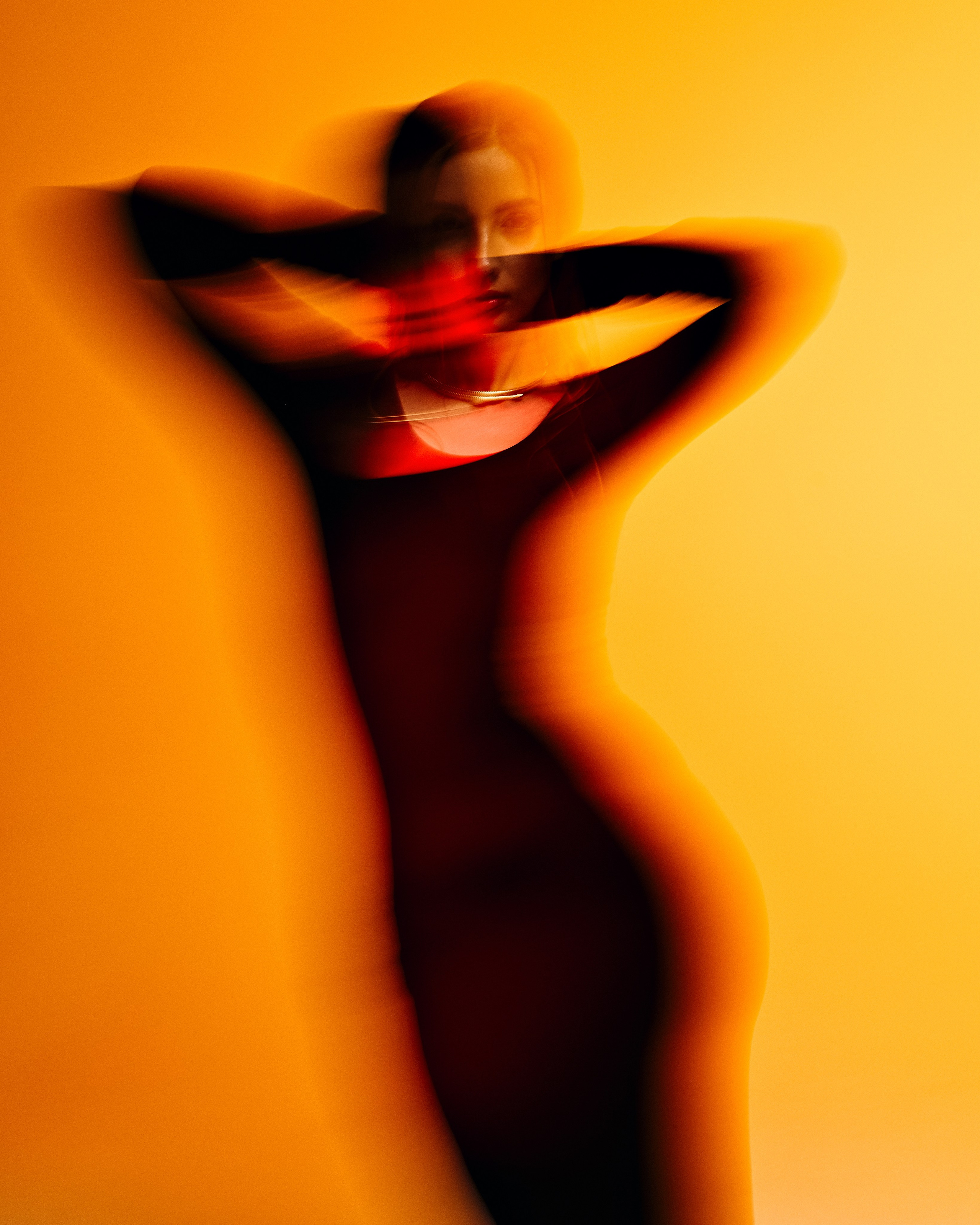 Студийная съёмка девушки с ярким красно-желтым фоном