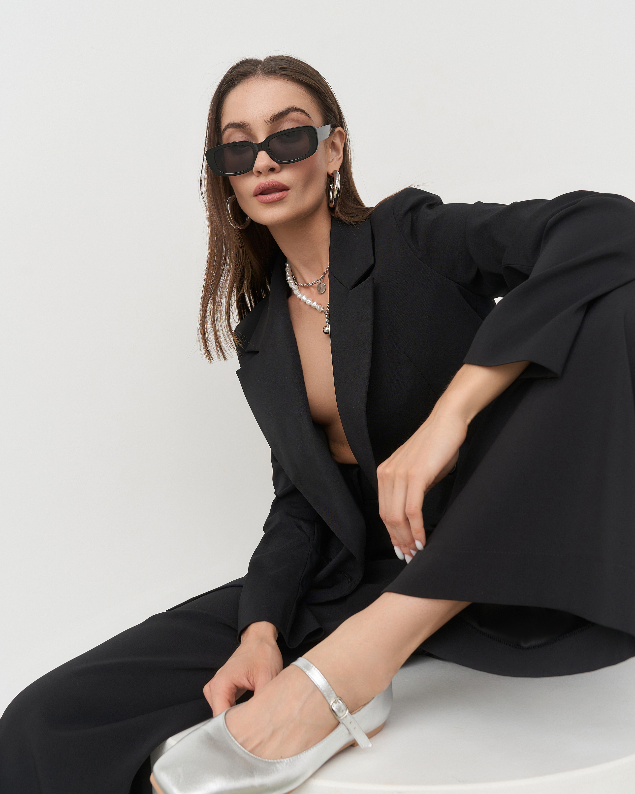 Модель сидит в стильном костюме Brandwomen