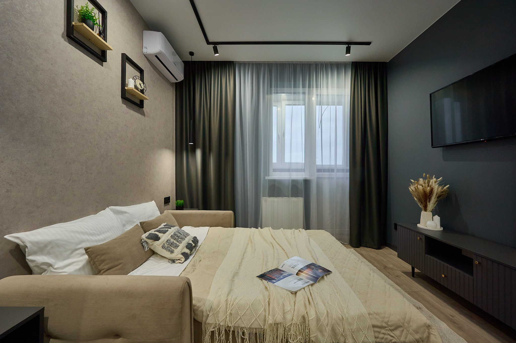 комната кровать черные полки телевизор темные шторы тумбы у кровати 