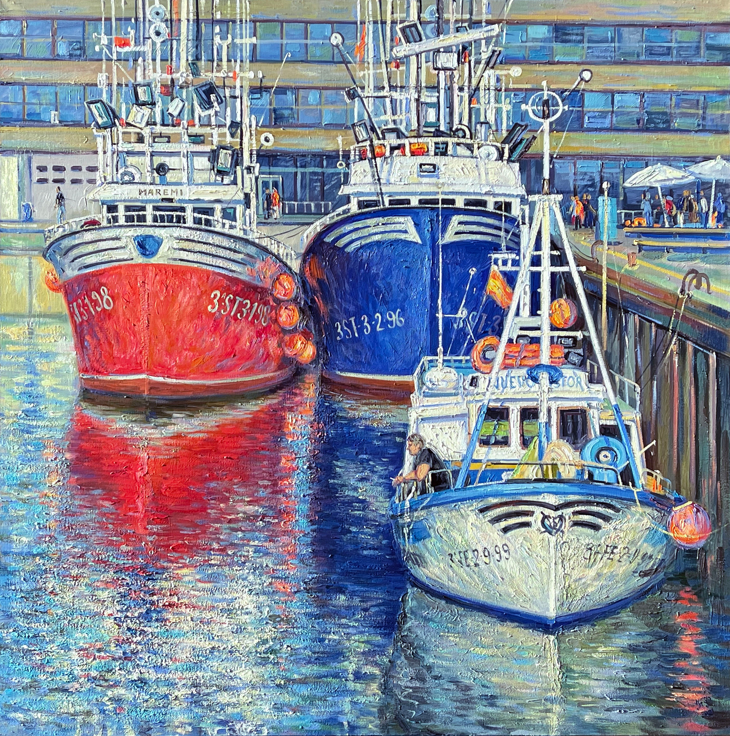 Fishing boats: red, blue and white standing by the pier