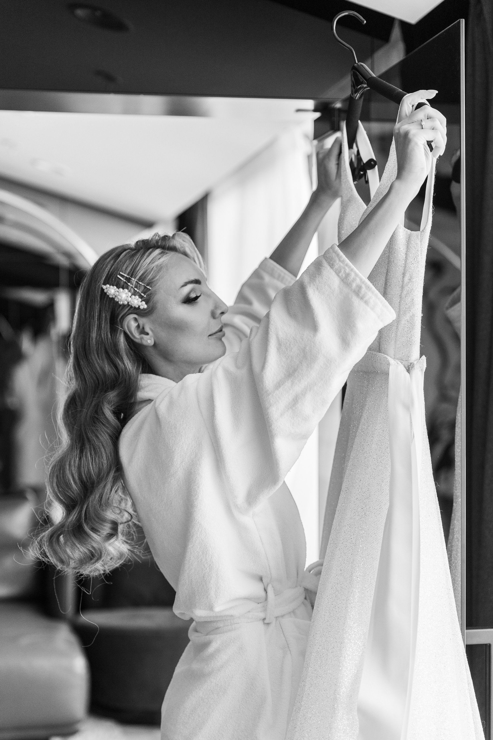 Невеста снимает свадебное платье с вешалки