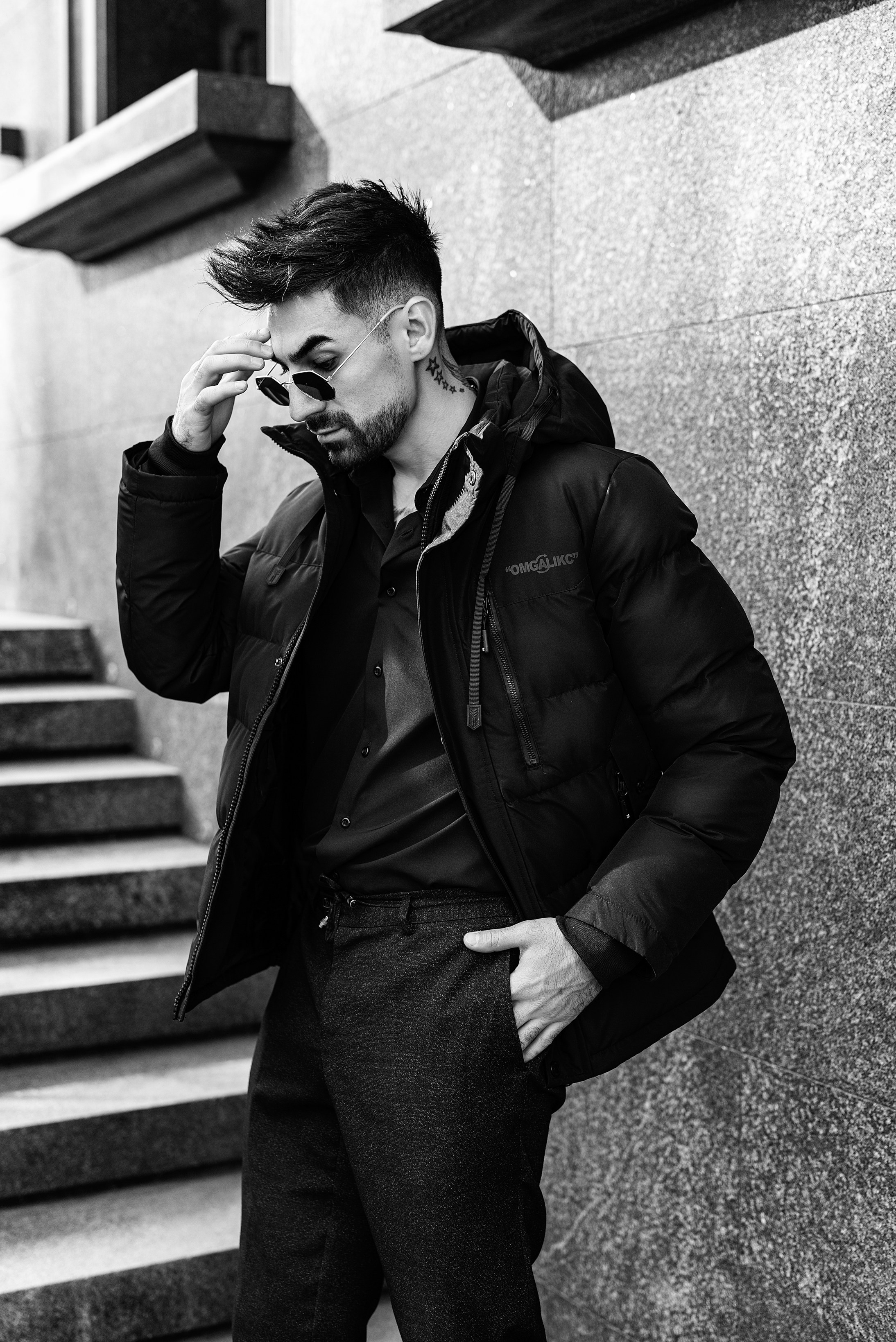 Красивый молодой человек в очках и деловой одежде, позирует фотографу на улице