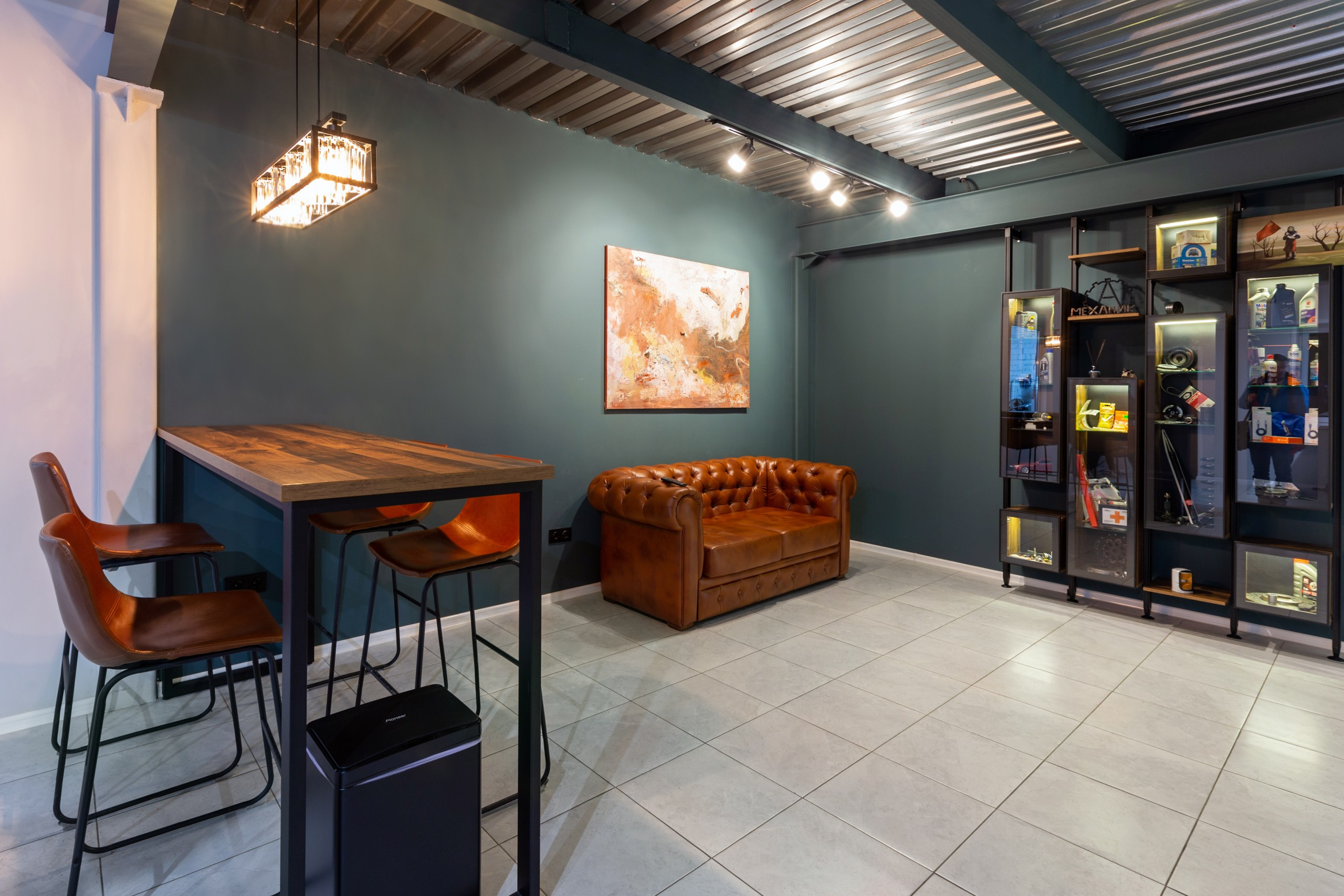 Деревянная барная стойка со стульями, деревянный стол и стулья, лофт. Холл с стиле лофт. Коричневый кожаный диван.