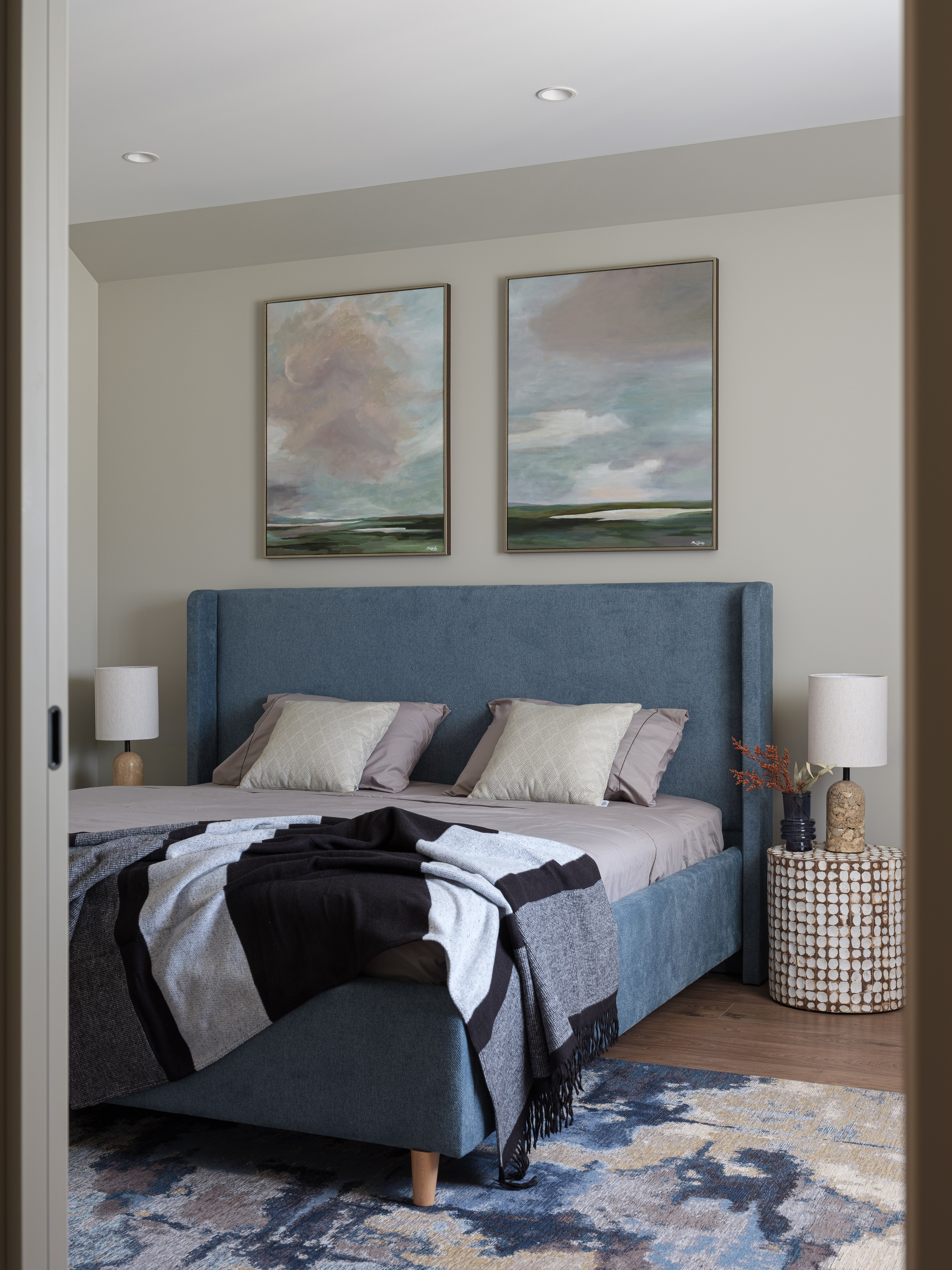 Современный дизайн интерьера спальни в спокойных тонах с мягким изголовьем кровати, стильным текстилем и акцентным ковром. Фото создано дизайнером Татьяной Диденко, стилистом Натальей Якушевой и фотографом Сергеем Денисенко.