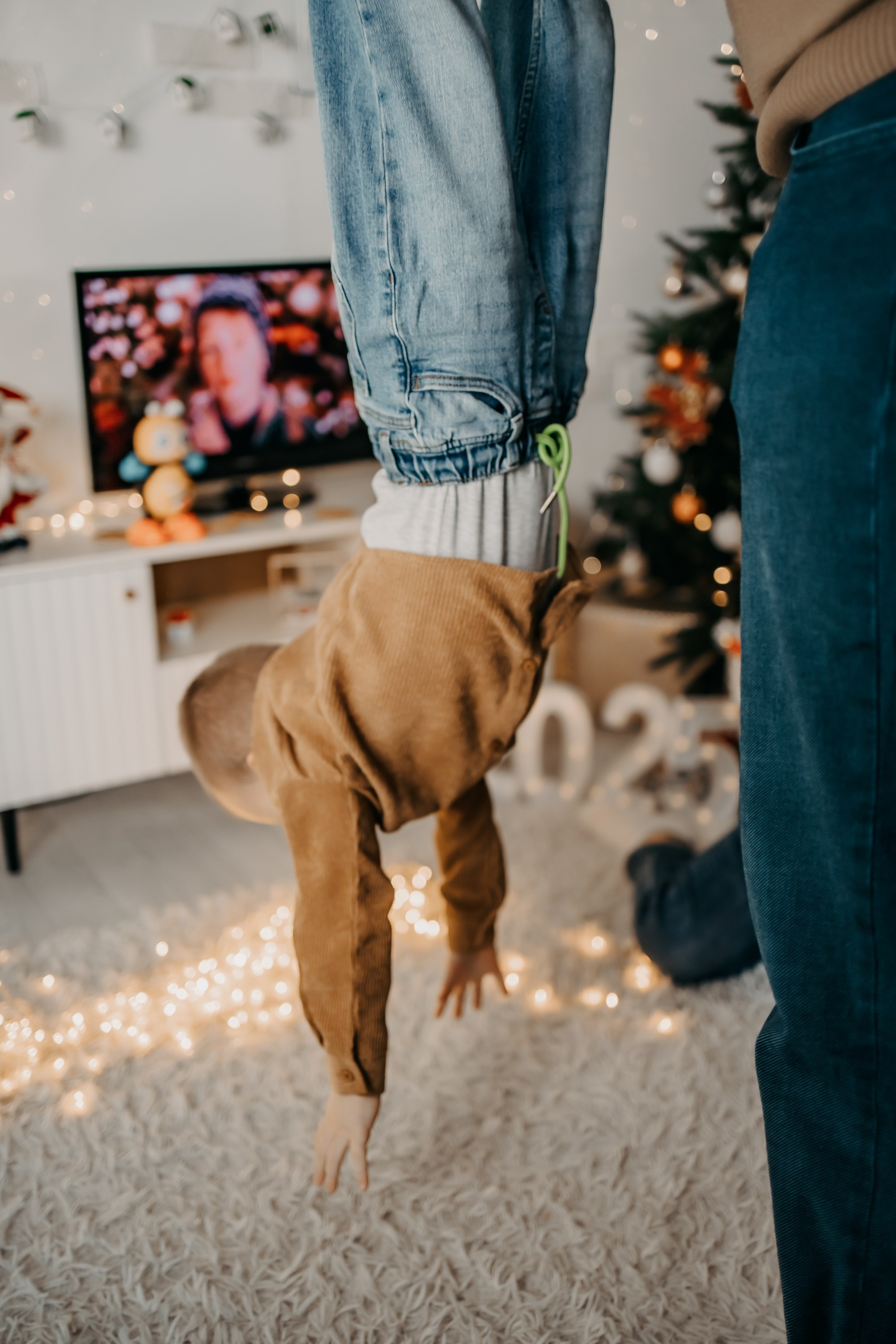 Семья улыбается и обнимает своего ребенка, отмечая его первый день рождения на семейной фотосессии