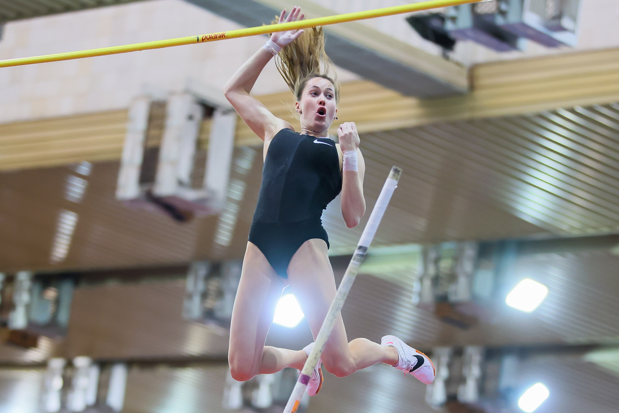 Полина Кнороз перелетает через планку в  прыжке с шестом