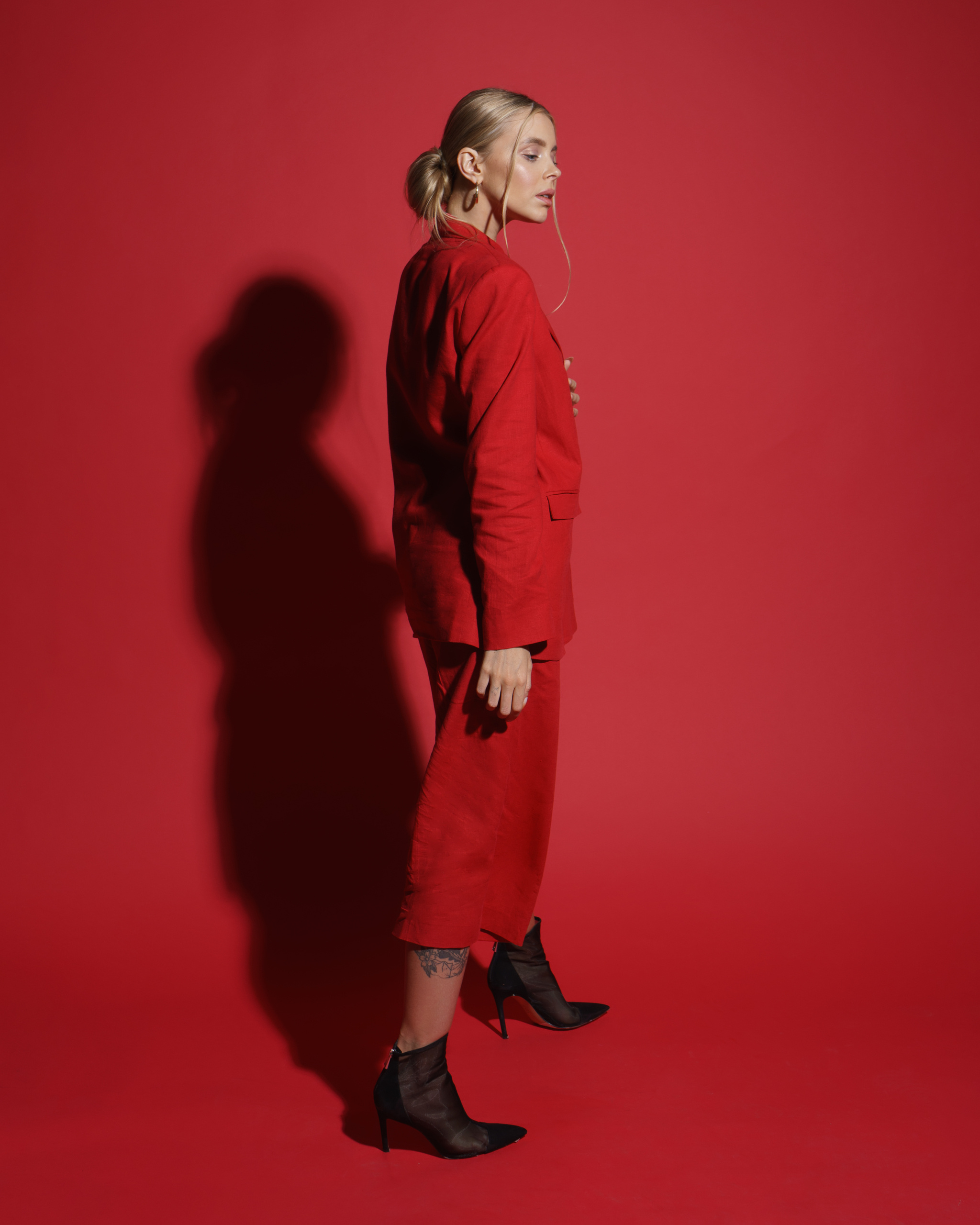фотосессия девушка в красном костюме на красном фоне в студии