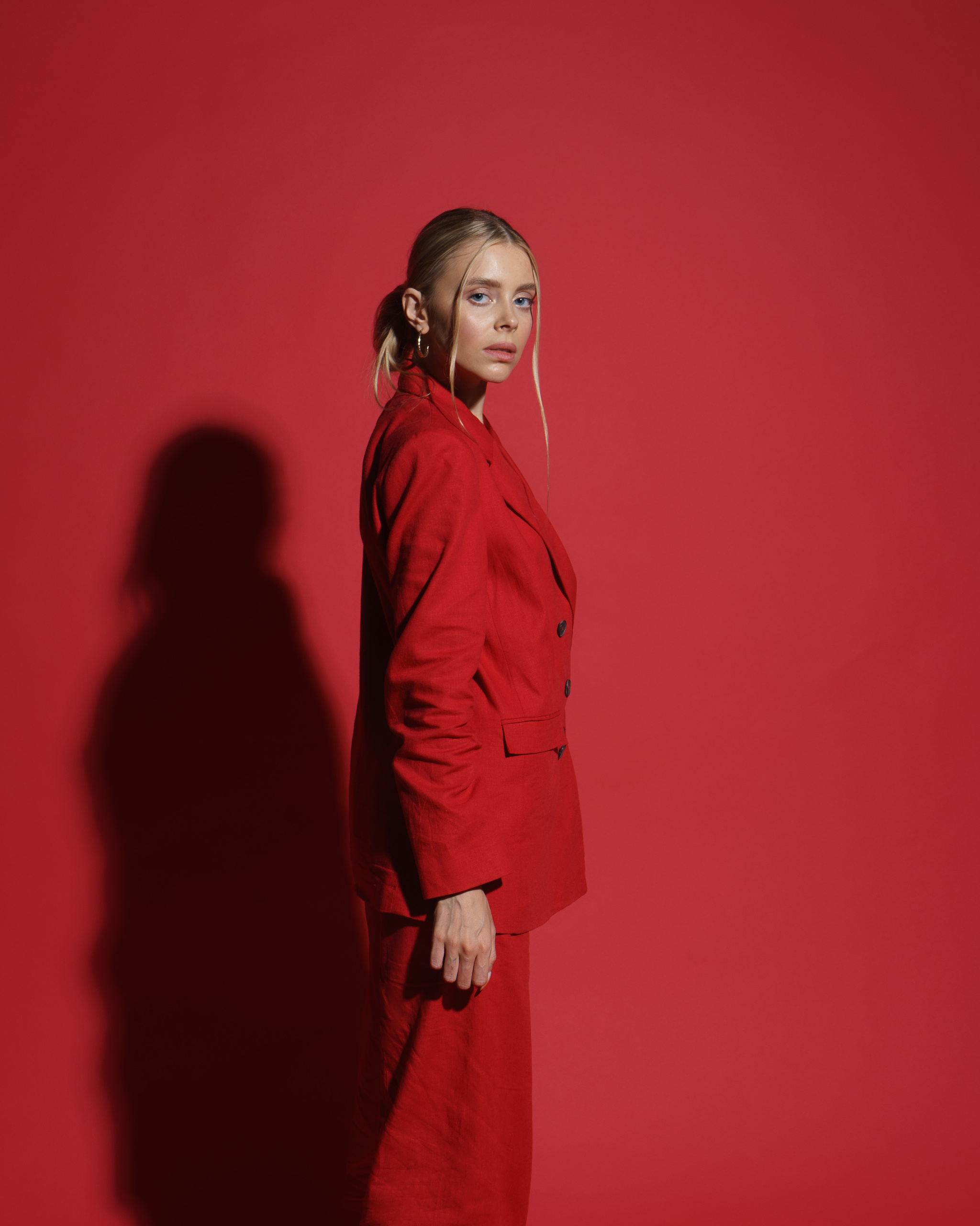 фотосессия девушка в красном костюме на красном фоне в студии