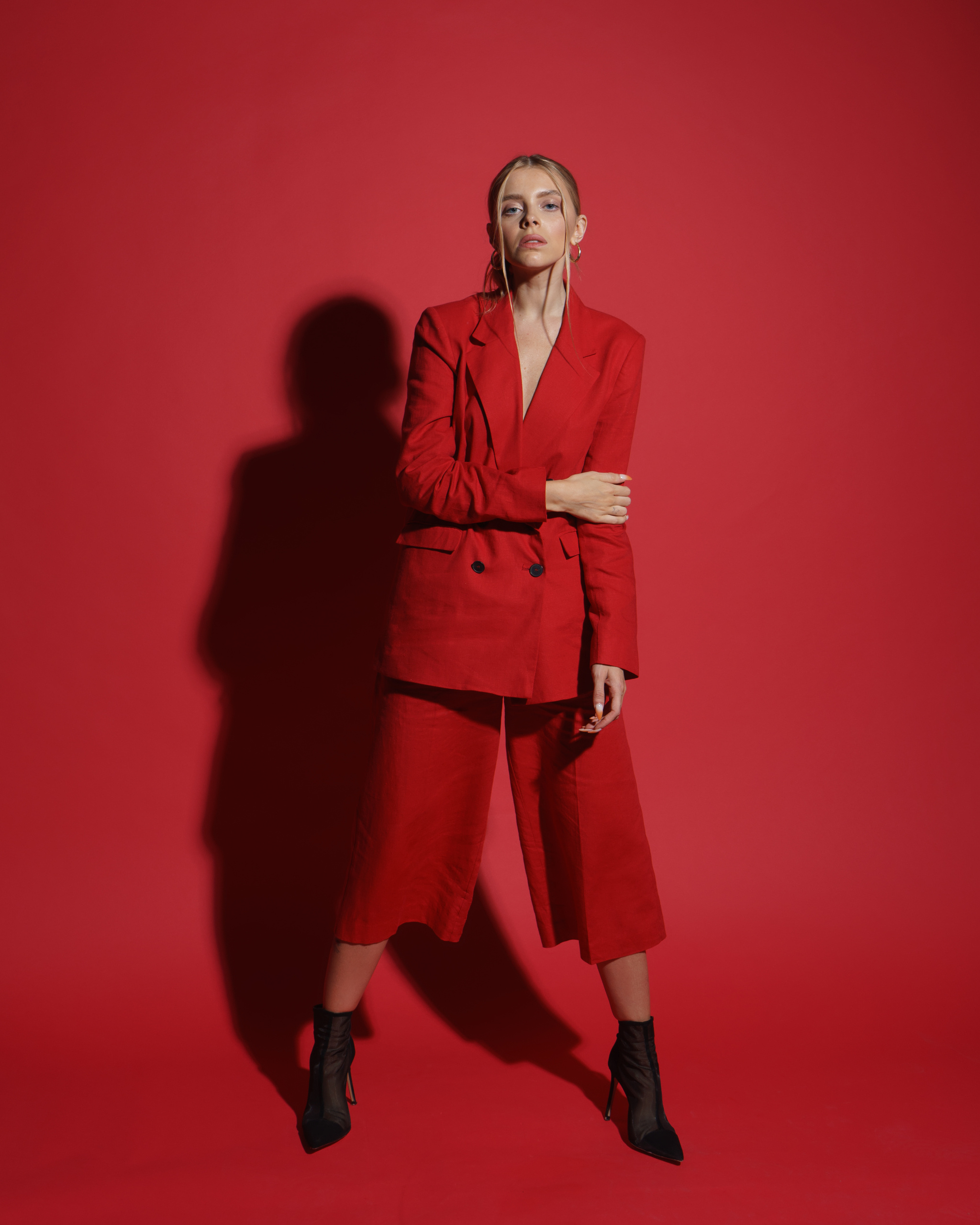 фотосессия девушка в красном костюме на красном фоне в студии
