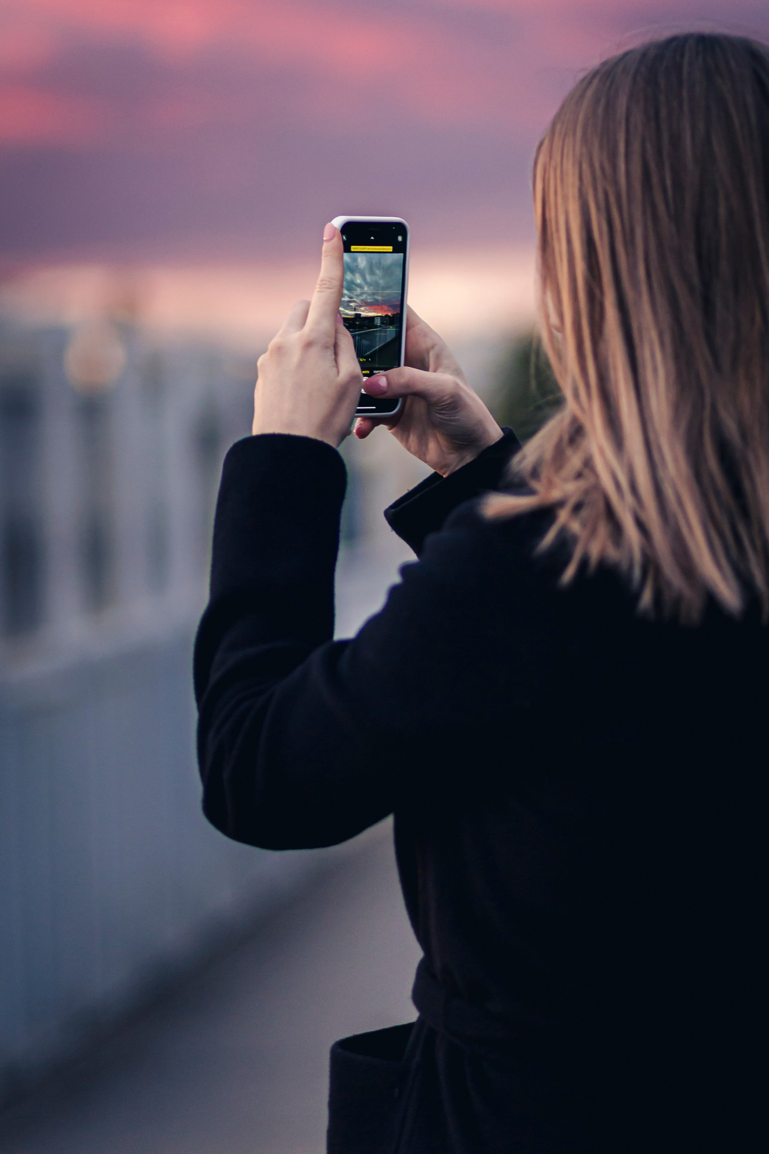 девушка фотографирует малиновый закат 