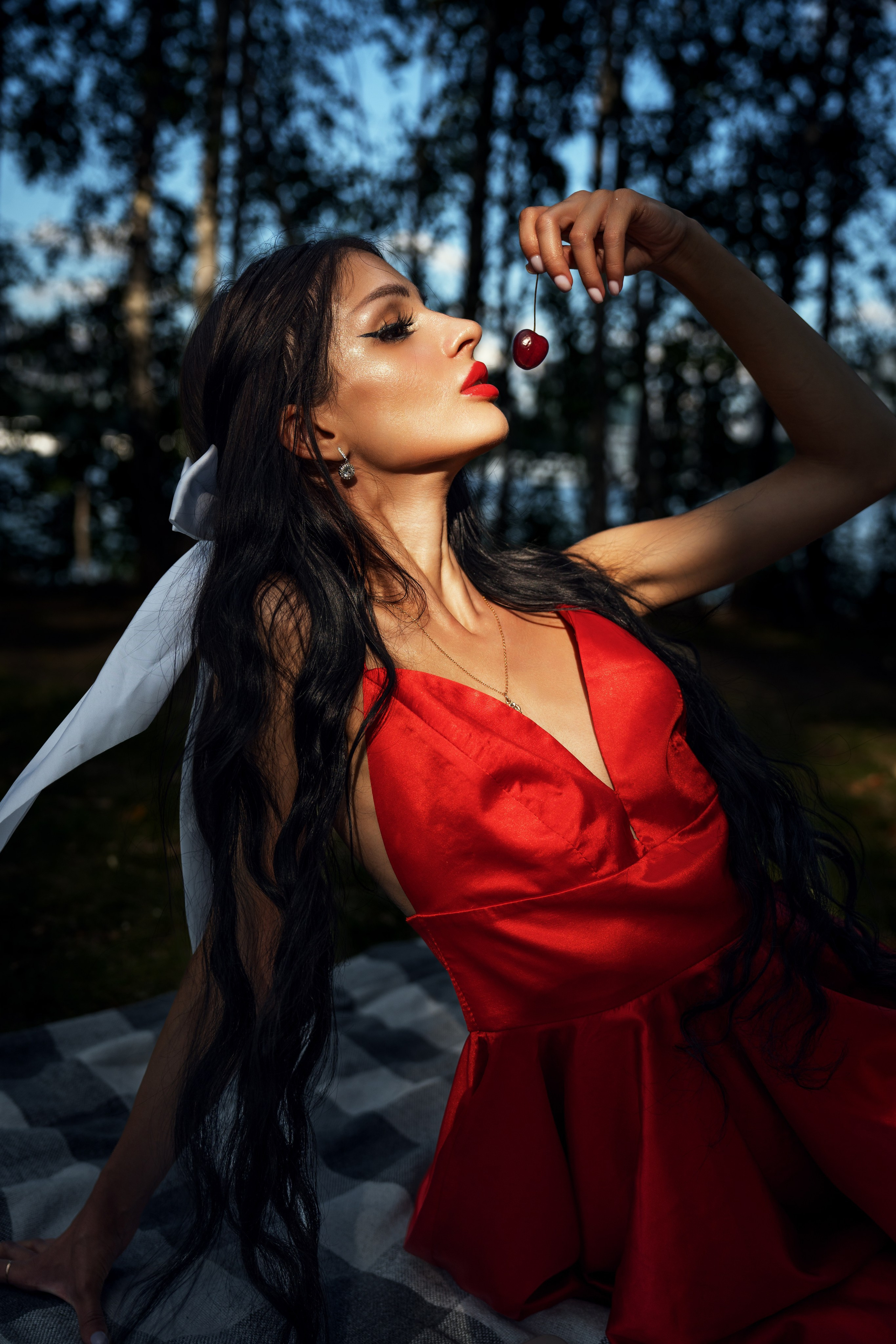 девушка на пикнике в парке Москвы в красном платье и с черешней