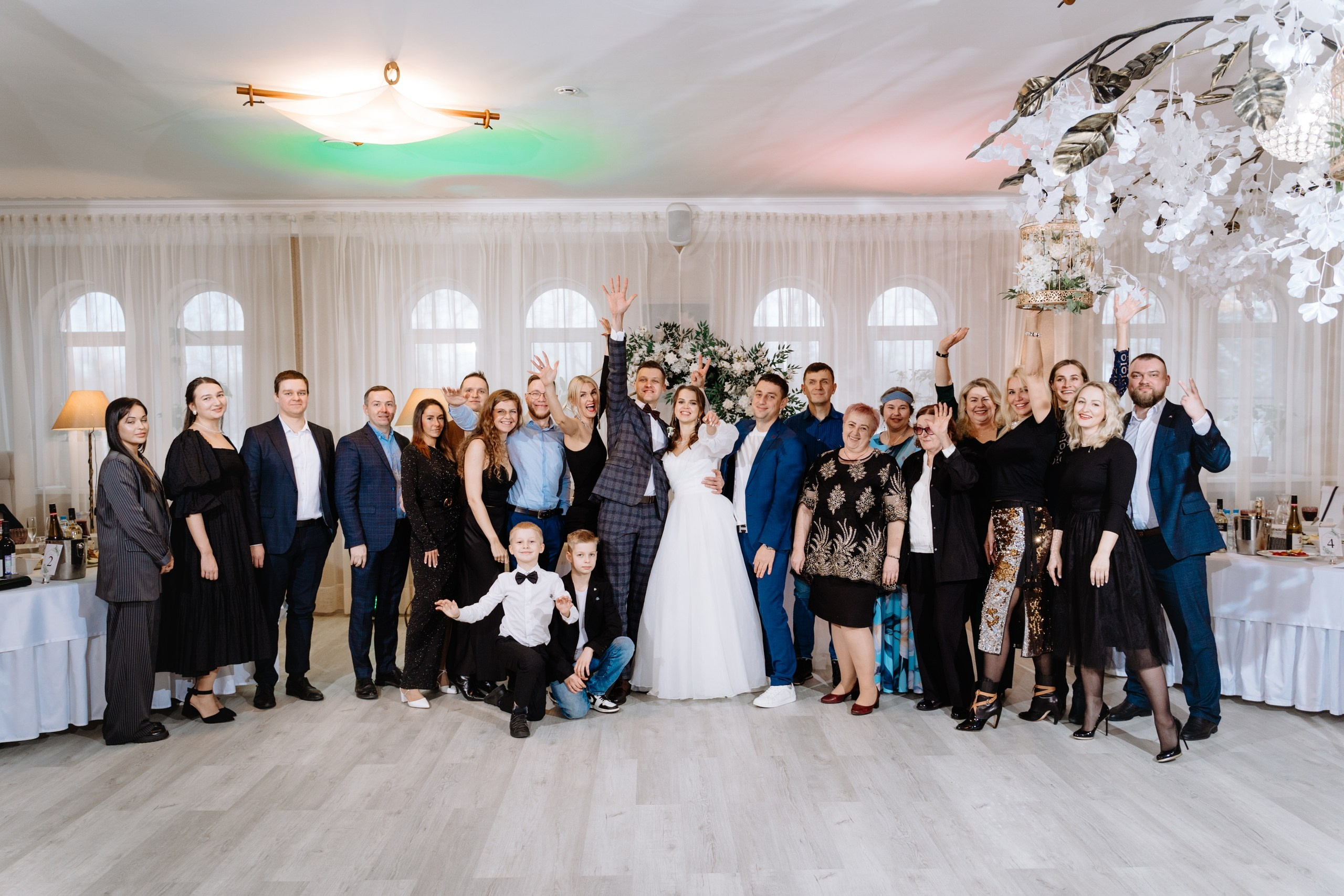 На фото невеста и жених в военной форме и гости на свадьбе.