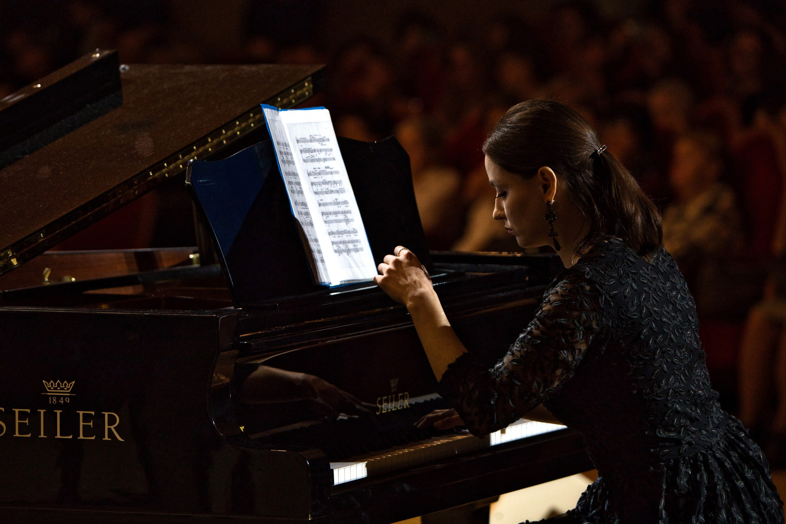 Пианистка играет на концертном рояле Seiler с нотами во время выступления, классическая музыка, профессиональная съемка фортепианных концертов