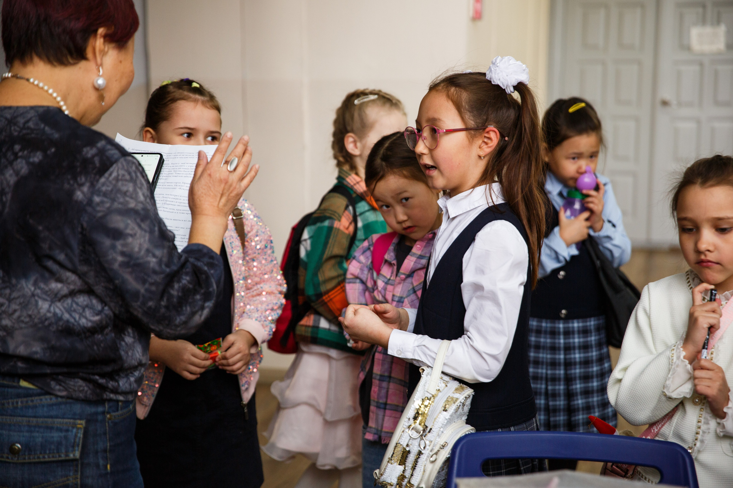 Женщина объясняет задание группе детей.