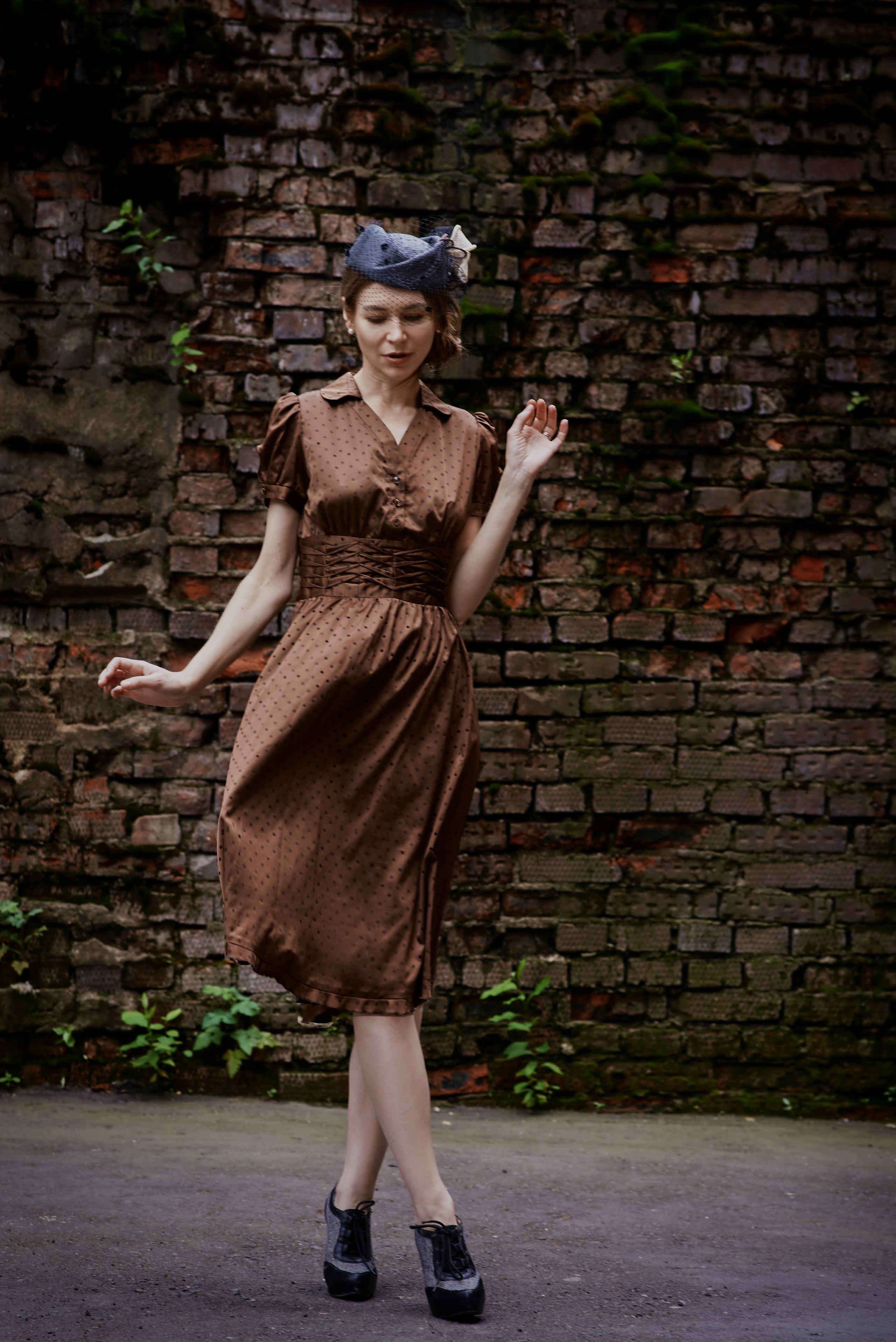 Фотосессия девушки в коричневом ретро платье в черный горох и в шляпке. Прокат ретро одежды