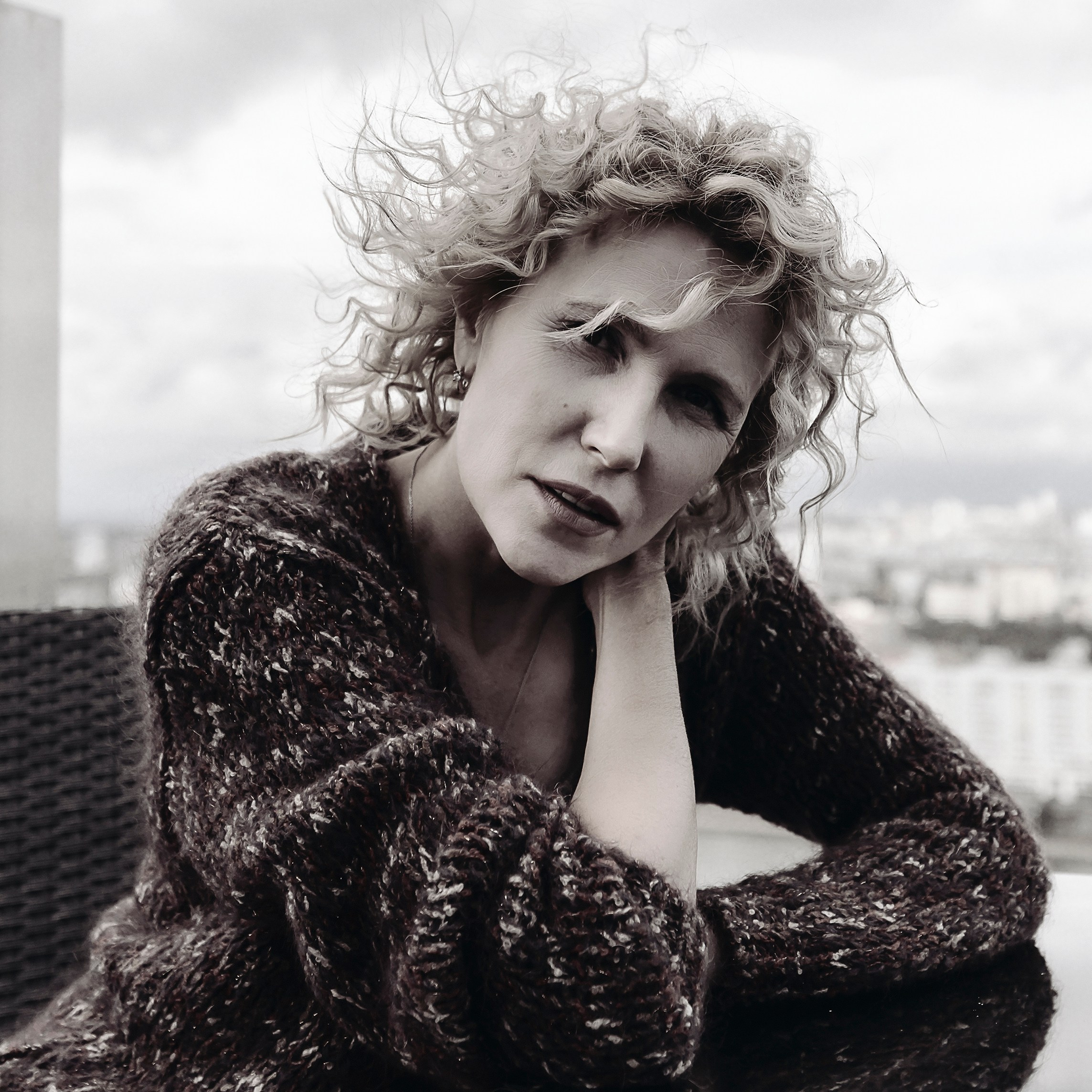 Портрет в крупном плане: женщина с длинными волосами и выразительными глазами, сделанный в естественном освещении.