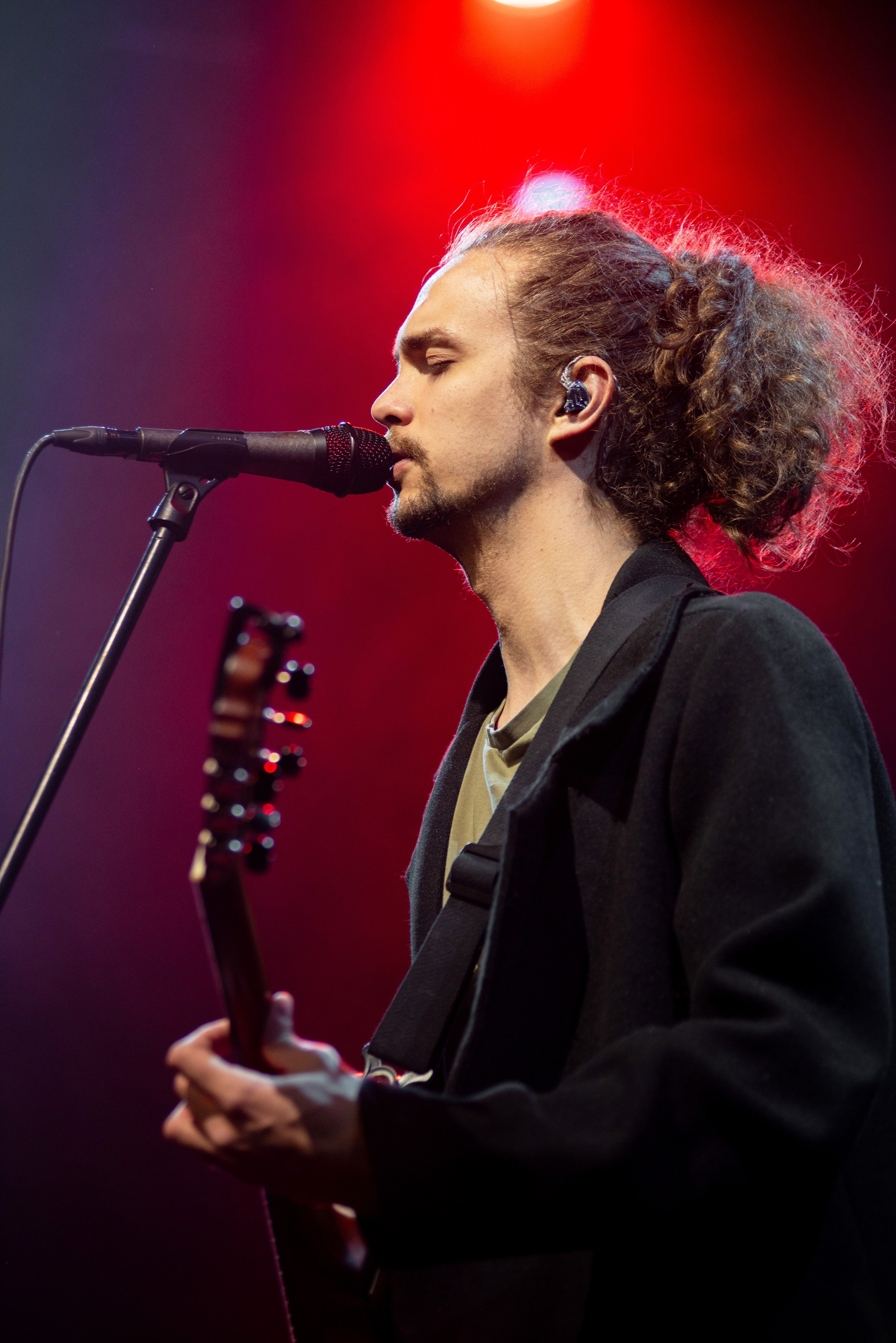 Вокалист группы «Лампабикт» с гитарой у микрофона на сцене Prime Hall в Минске