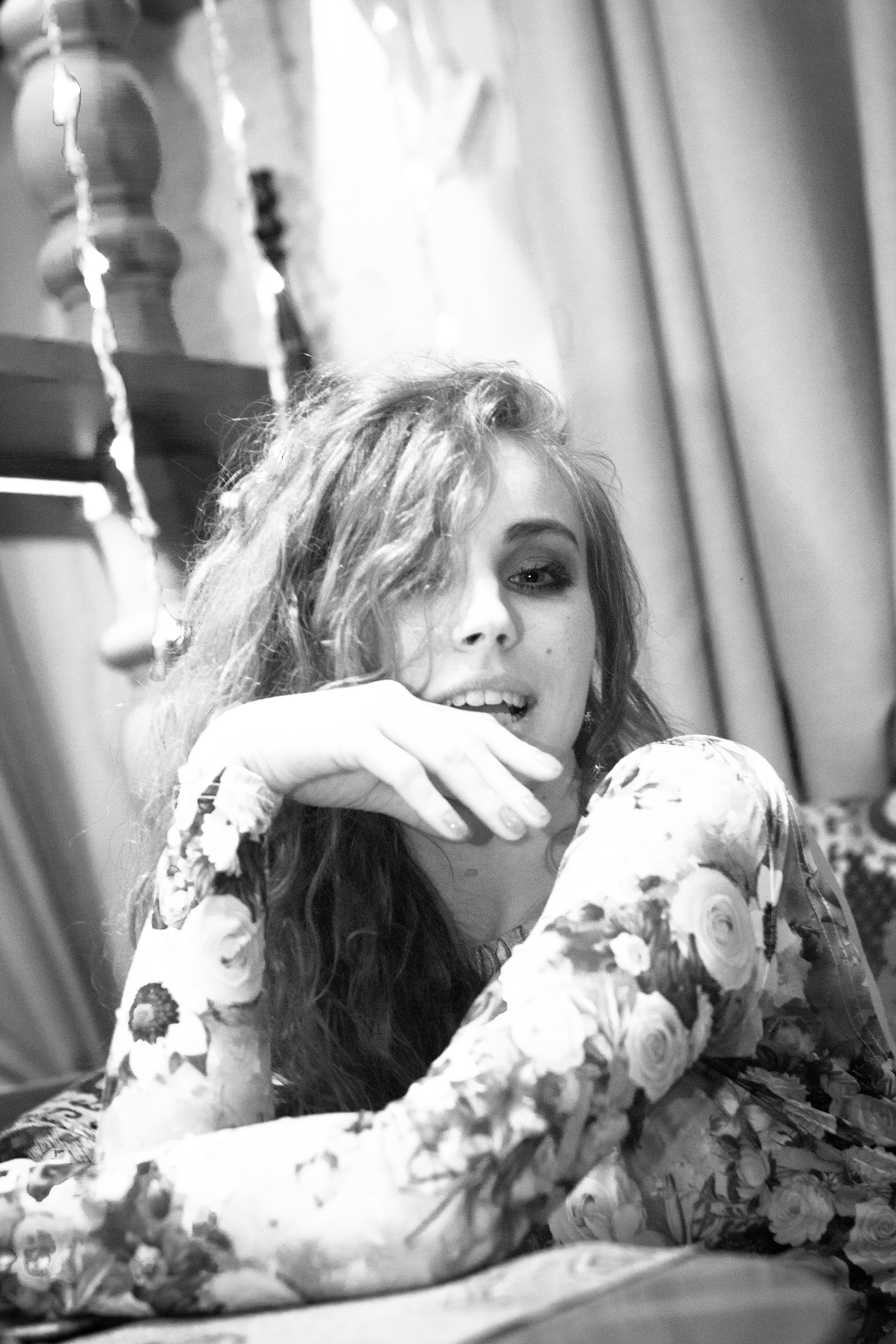 индивидуальное фото в черно белом фоне где девушка сидит облокотившись на руку 