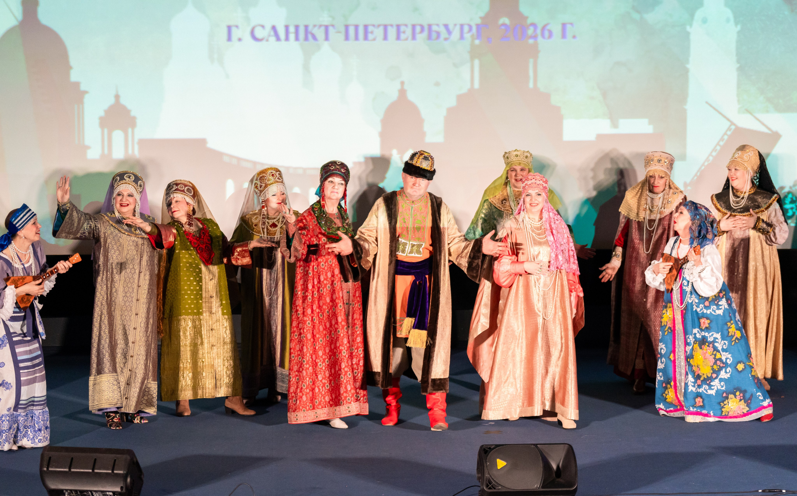 Коллектив в народных костюмах на сцене XII Международного фольклорного фестиваля «Сохраняем традиции». Санкт-Петербург, 2026. Фото: Мальцев Евгений.