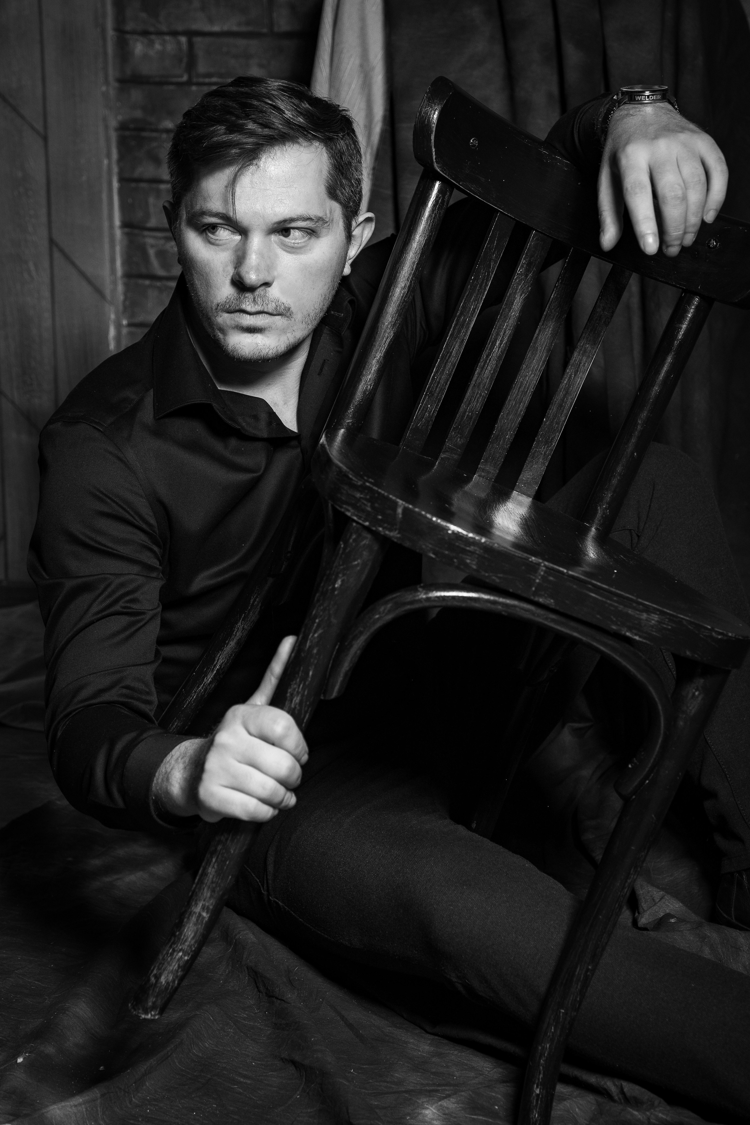 Брутальный мужчина позирует со стулом