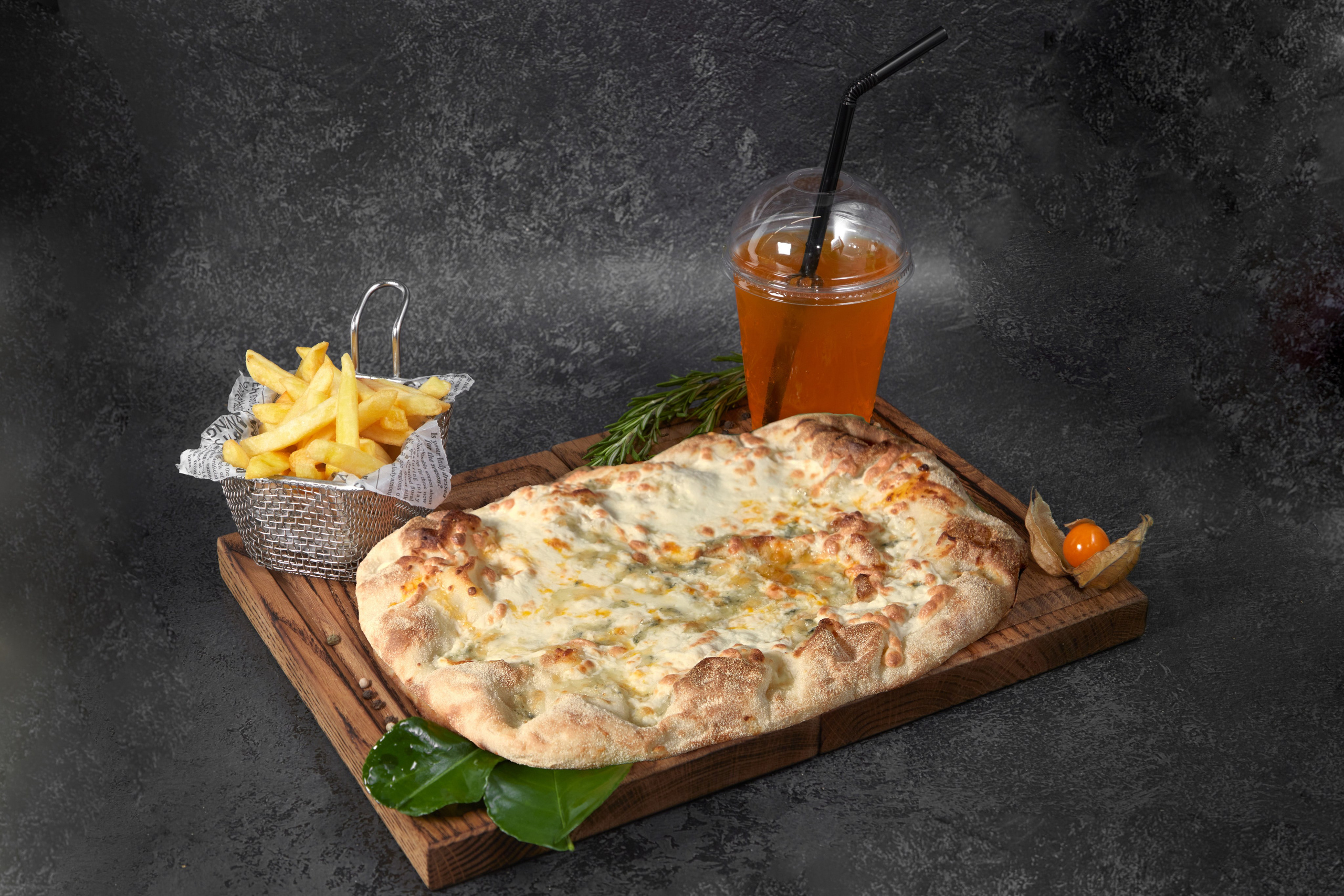 Пицца на деревянной доске с напитком.