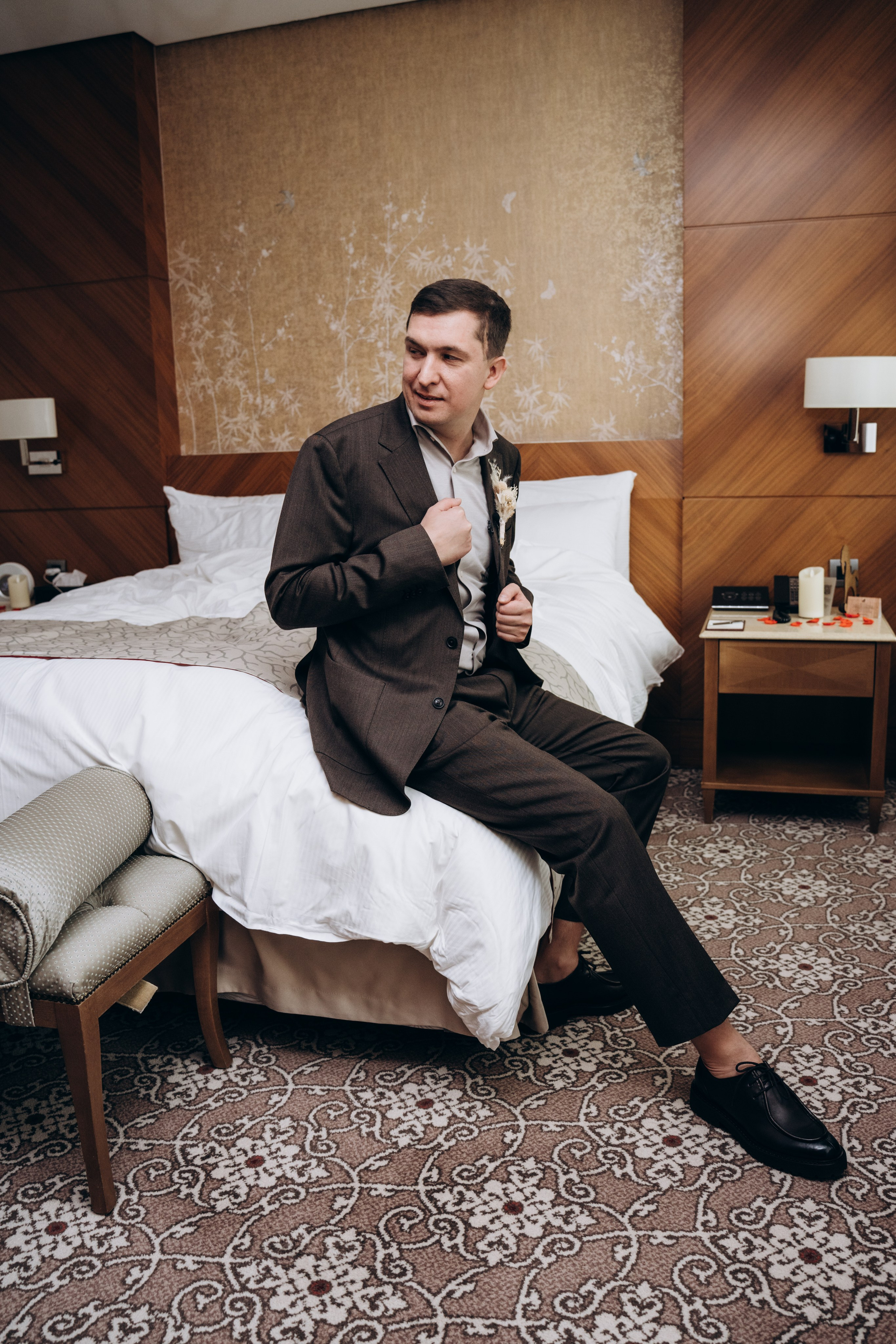 Жених смотрит в окно, задумчиво ожидая начала церемонии — атмосферные и искренние свадебные фотографии.