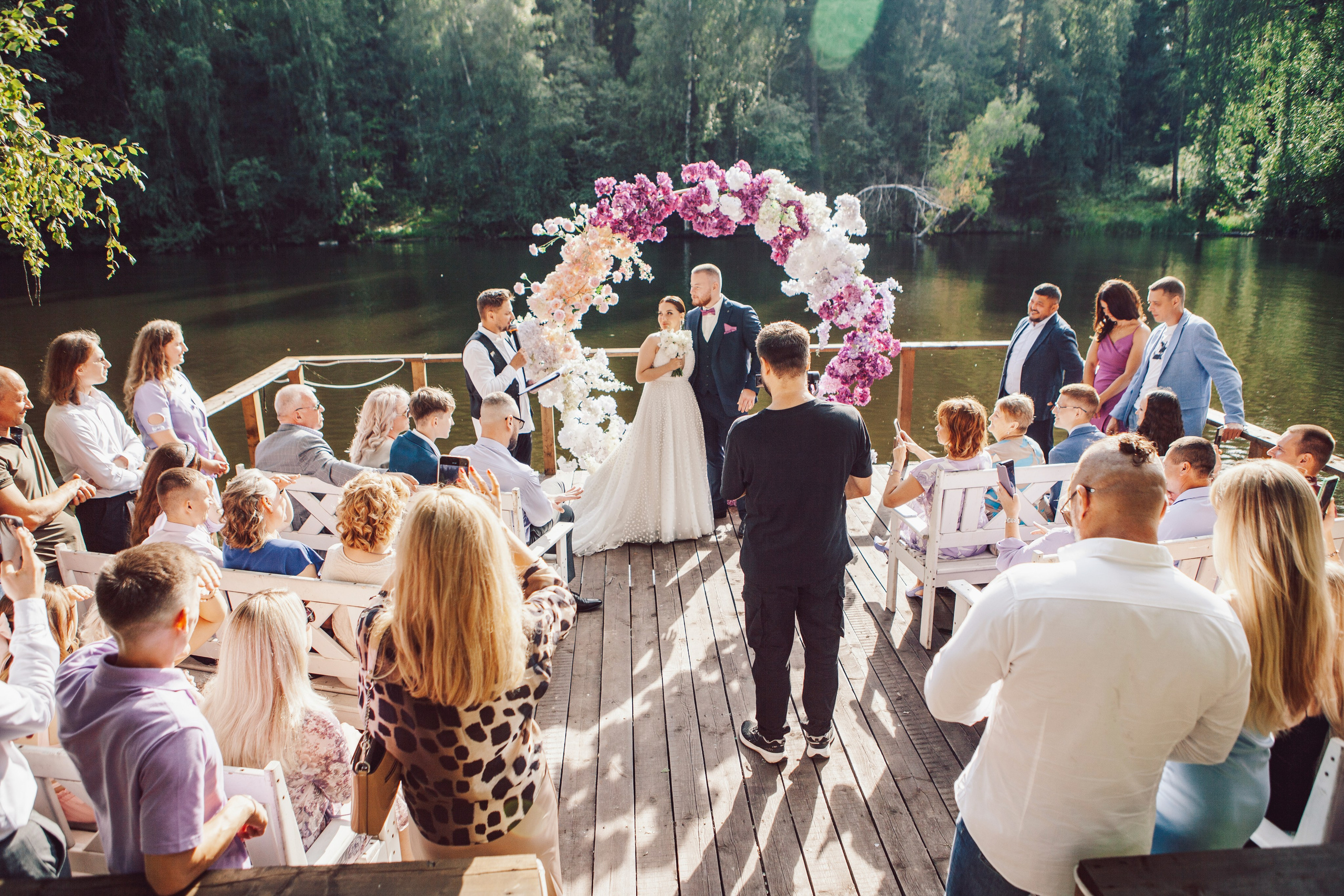 выездная регистрация молодоженов с аркой из цветов на фоне реки