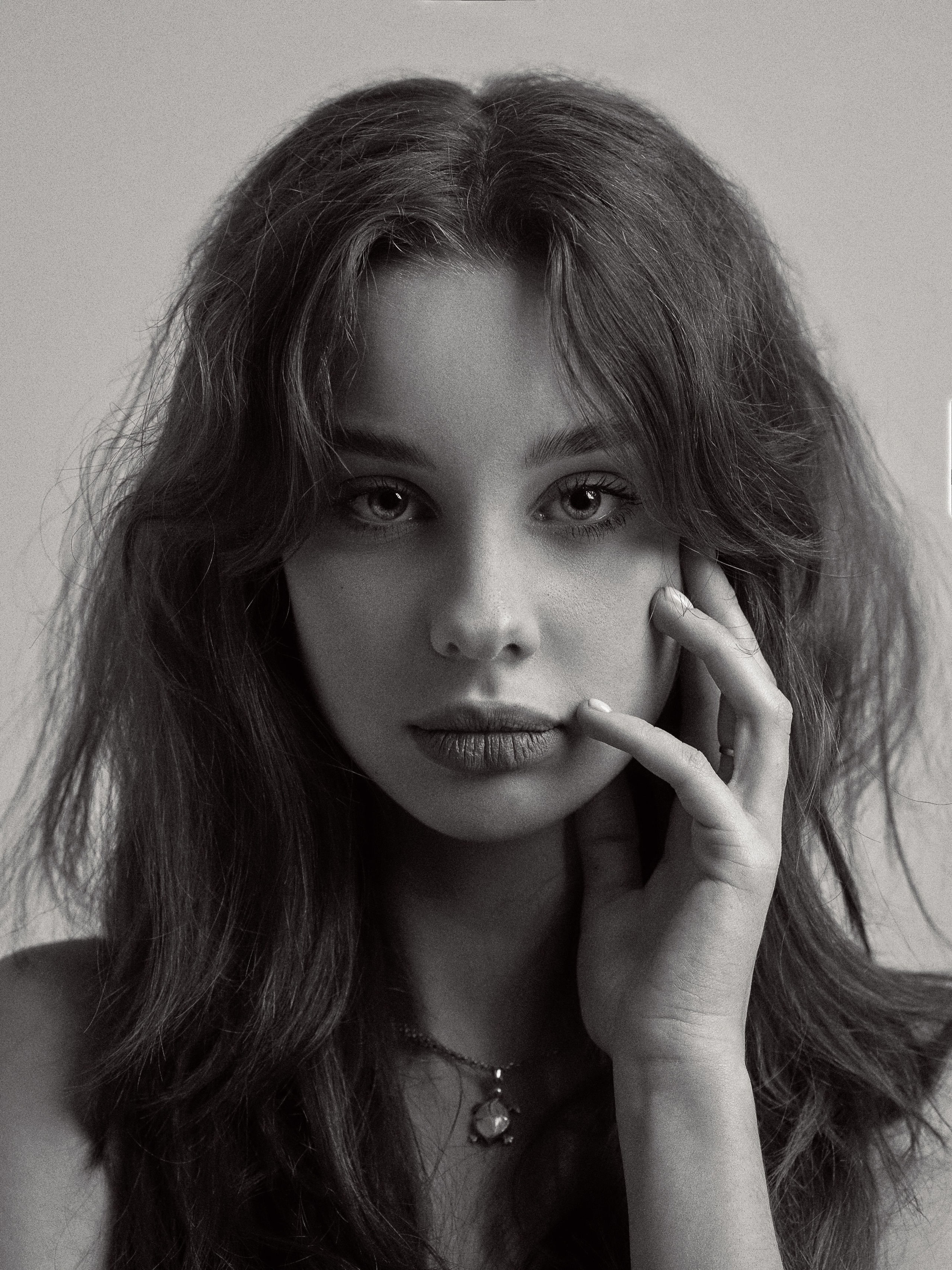 Черно-белый портрет девушки в фотостудии на белом фоне