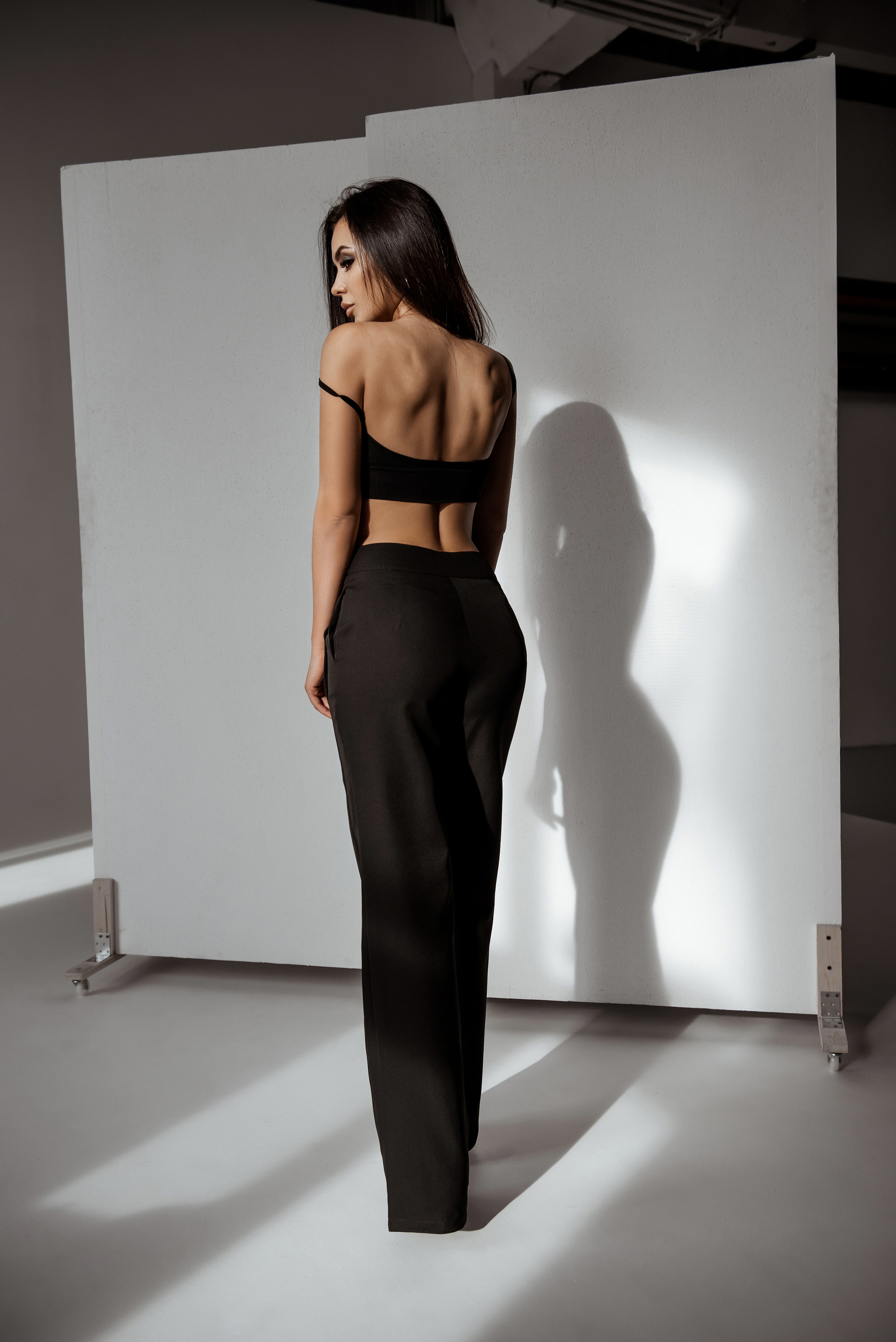 Фотография со спины красивой девушки в студии без интерьера